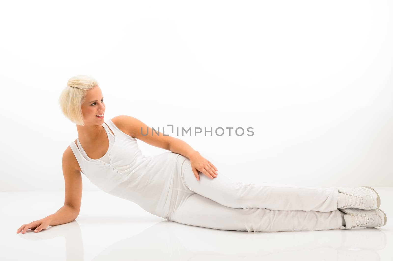 Woman stretching her body fitness exercise lying on white floor