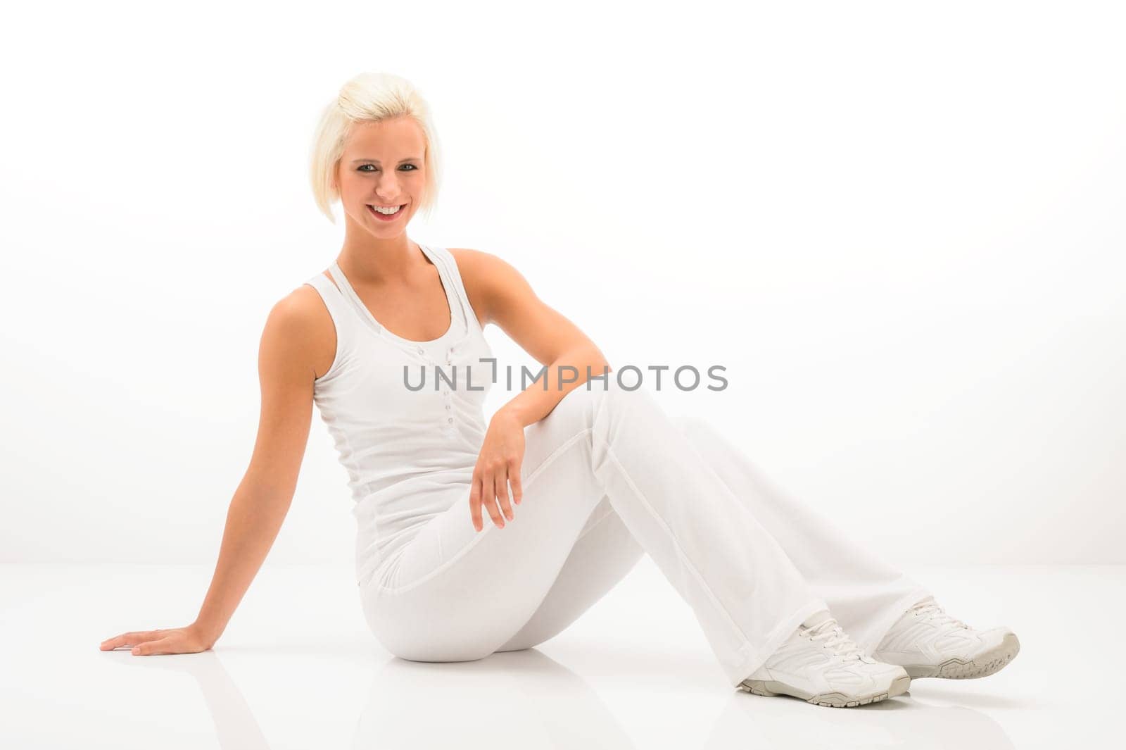 Attractive blonde woman relaxing during Pilates exercise on white background