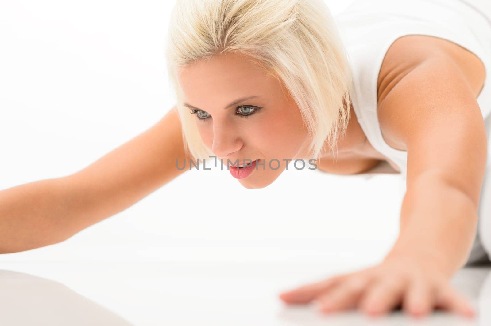 Young sportive woman doing push-ups on white background fitness exercise