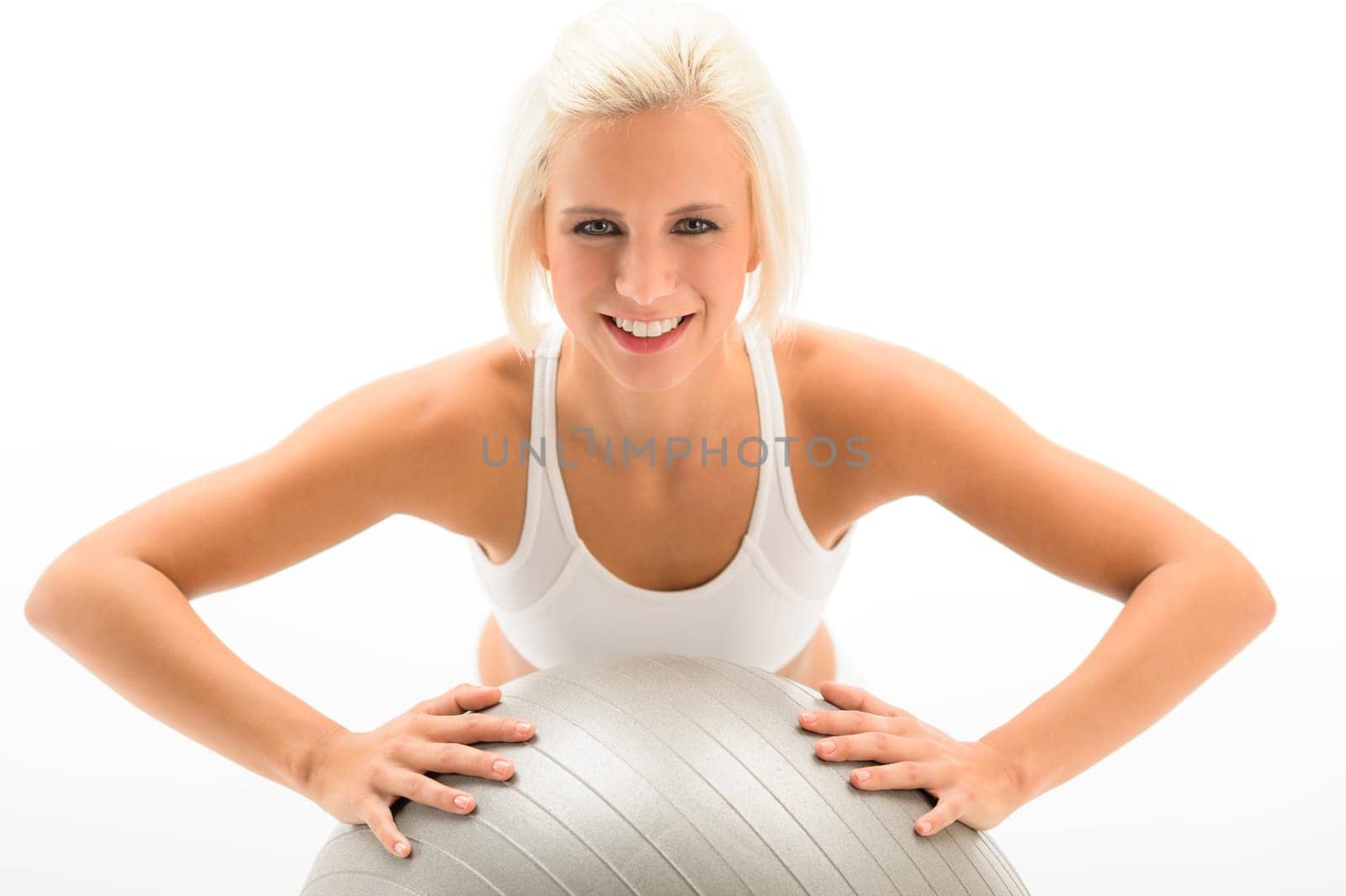 Smiling woman exercising on fitness ball on white background