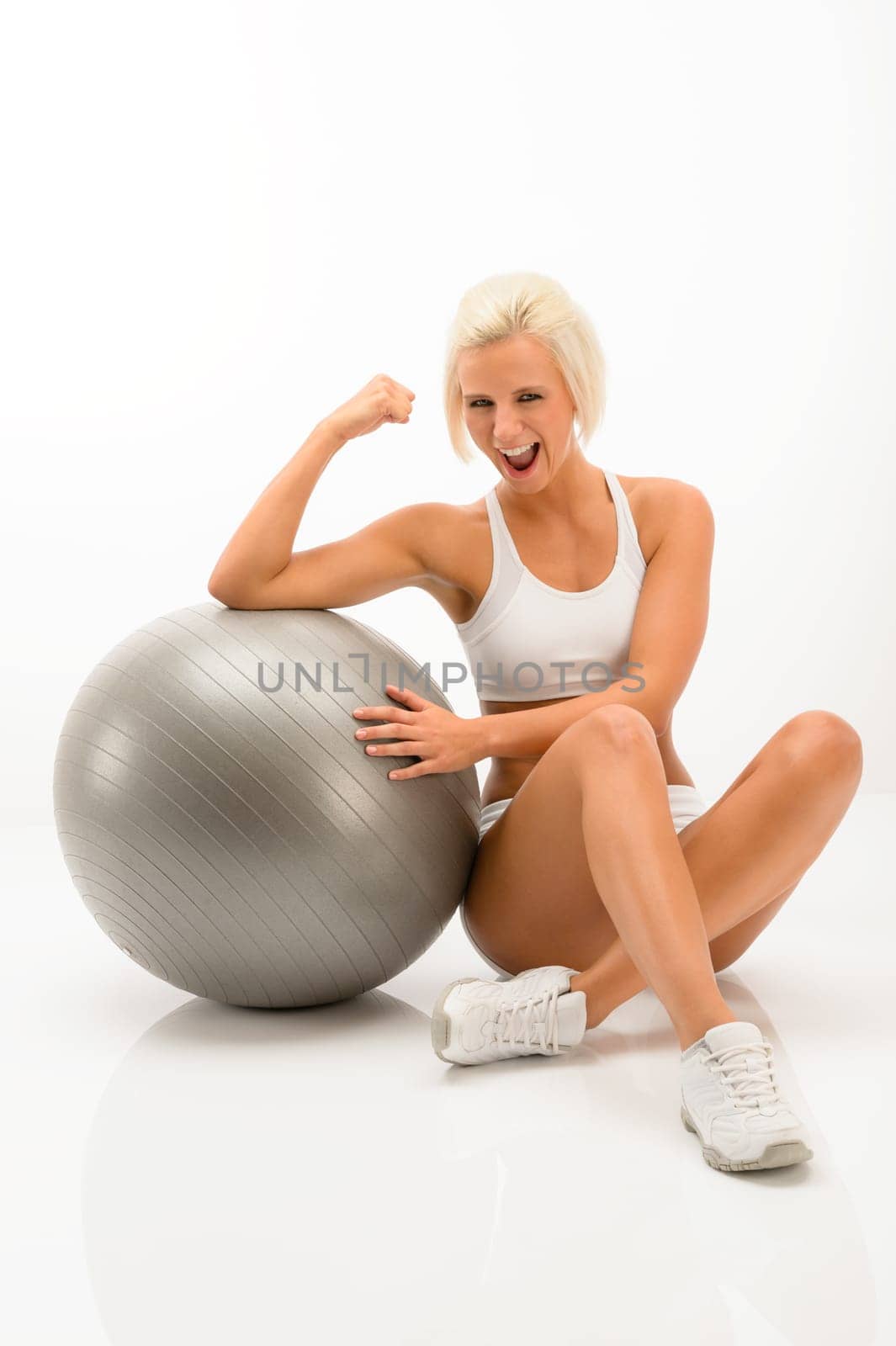 Cheerful woman posing with fitness ball isolated white background