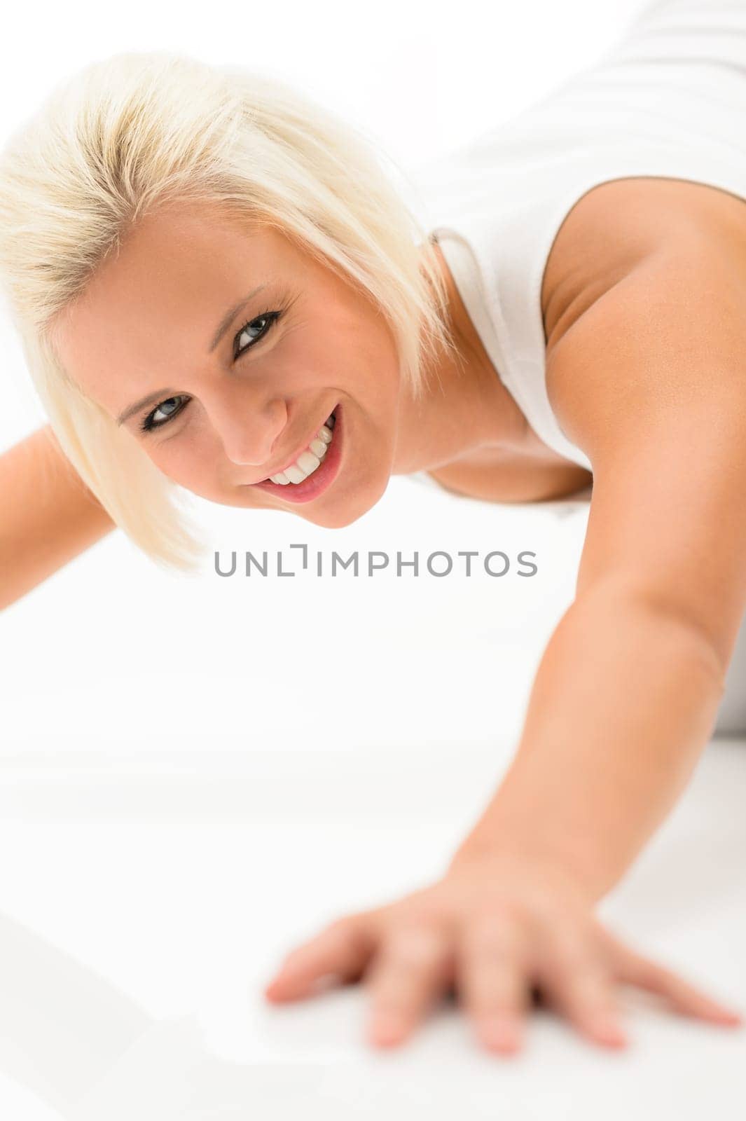 Young sportive woman doing push-ups on white background fitness exercise