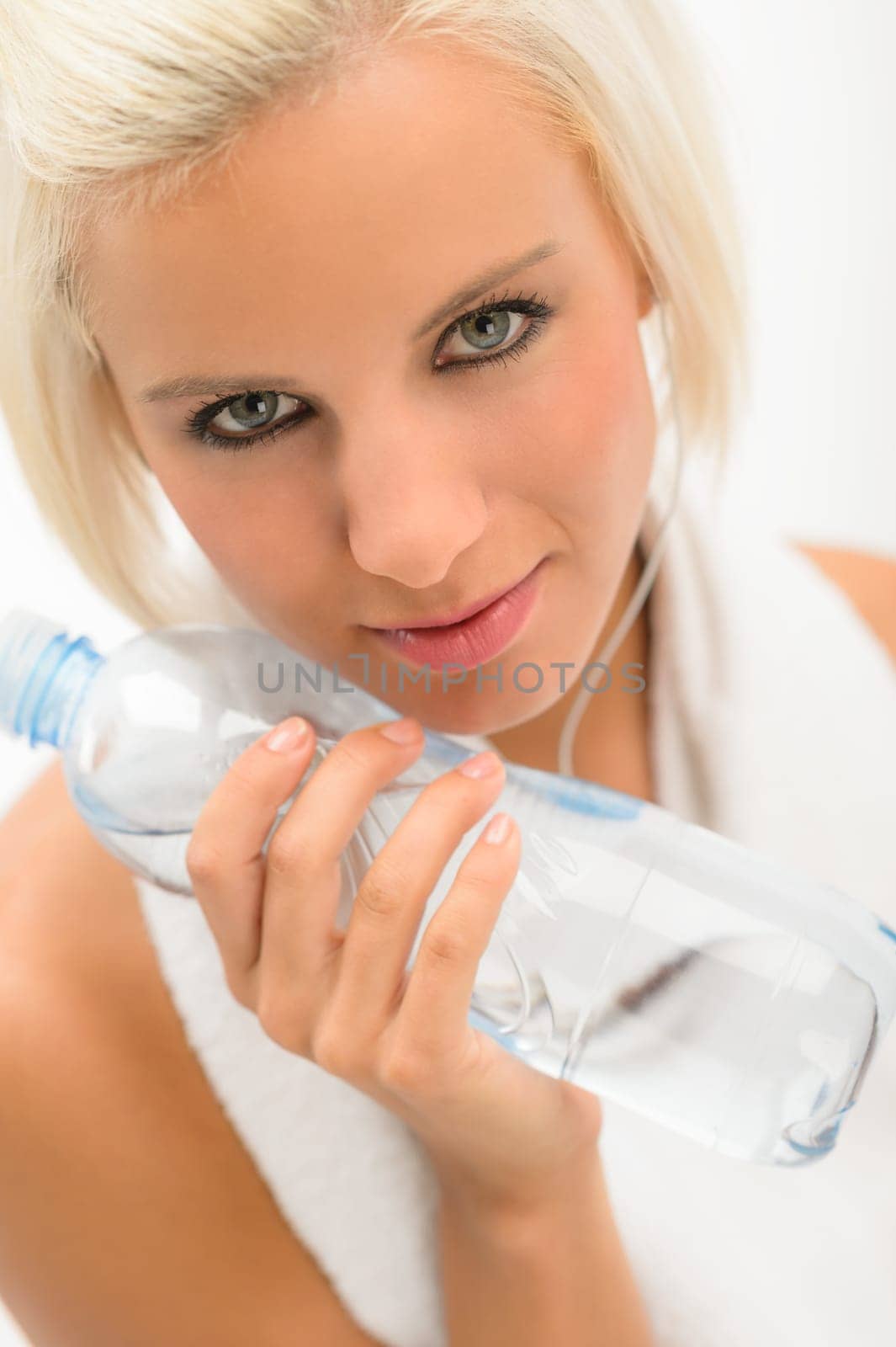 Fitness blond woman hold water bottle with headphones isolated white