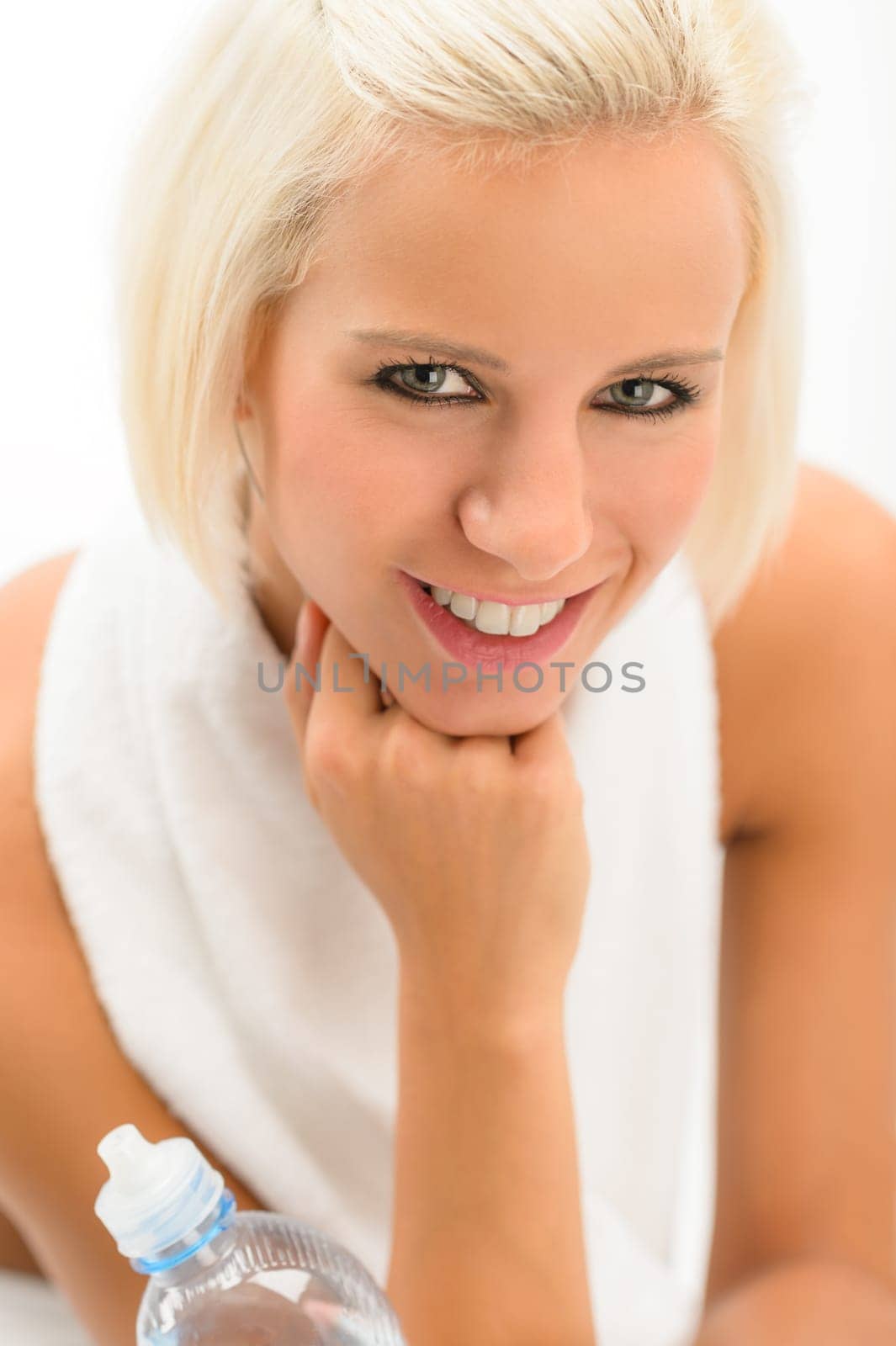 Fitness blond woman hold water bottle with headphones isolated white