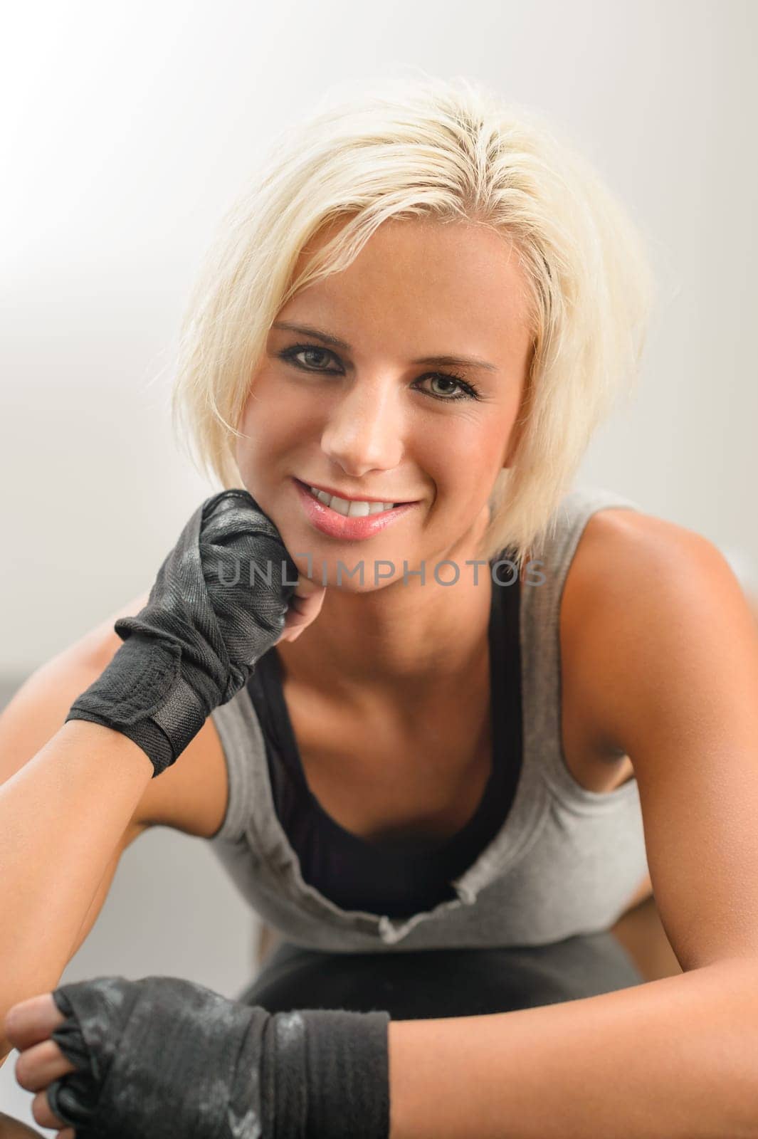 Female kick boxer laying down on black floor close-up portrait