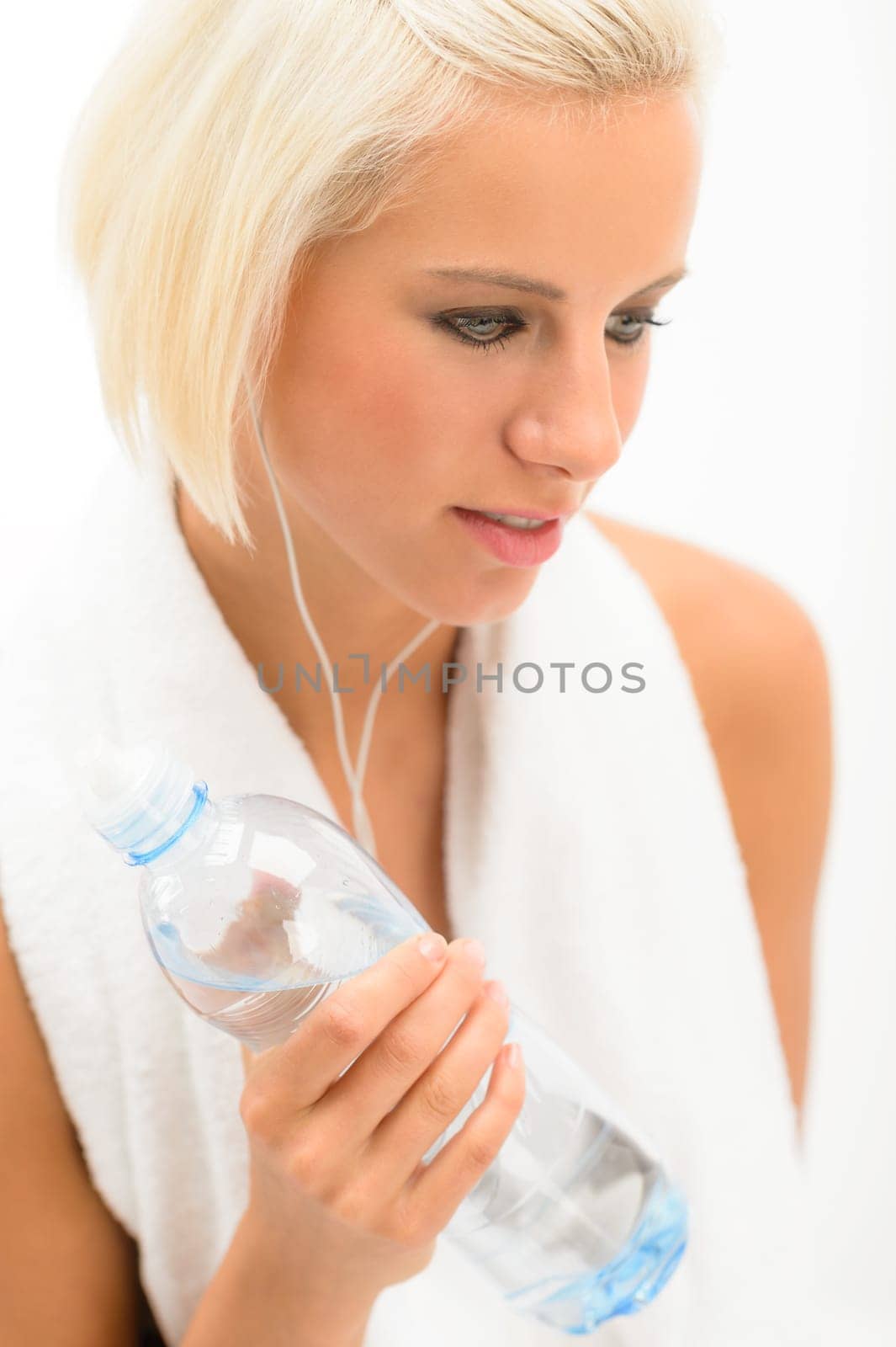 Fitness blond woman hold water bottle with headphones isolated white