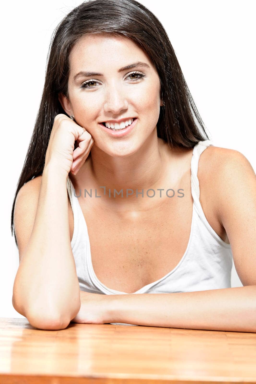 Beautiful young woman sitting next to a coffee table at home in casual clothes