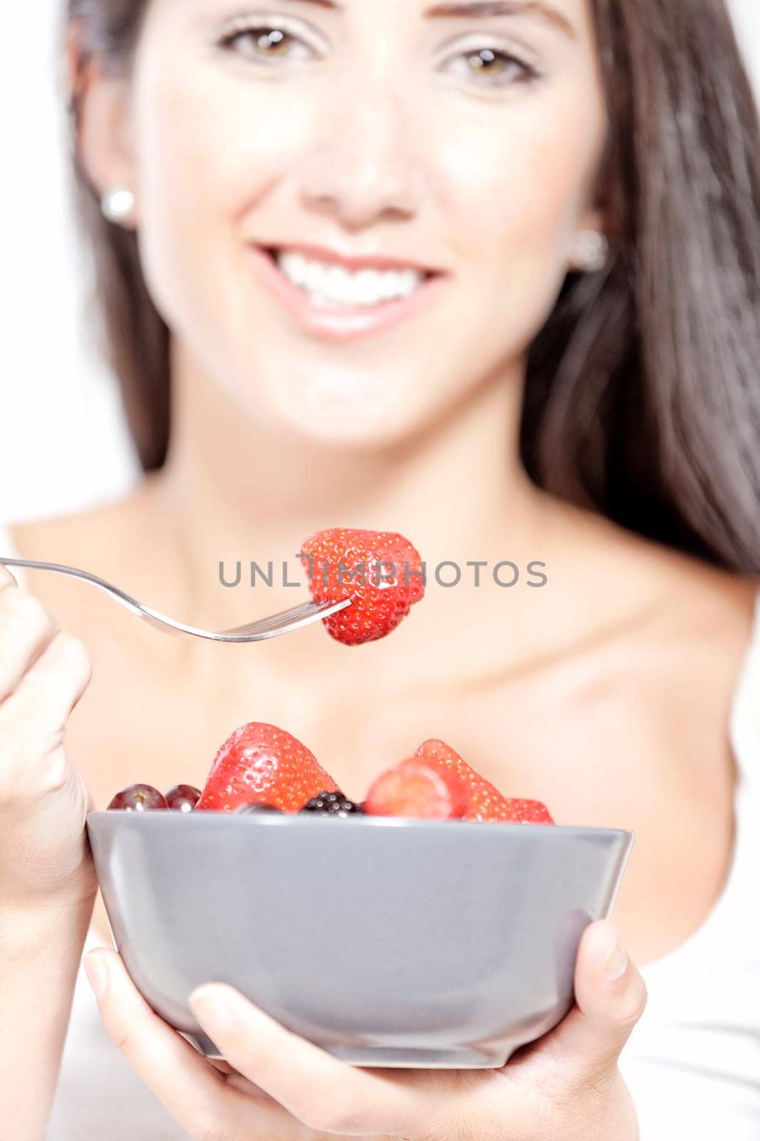 Beautiful young woman enjoying fresh fruit for breakfast at home