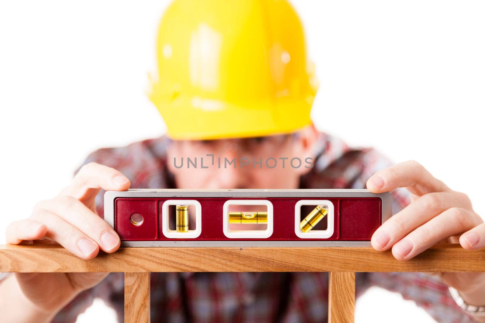 A construction worker using a level on a woodworking project