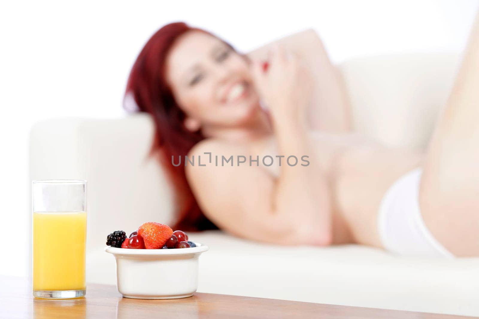Fresh fruit and Orange juice on a coffee table with sexy woman in the background
