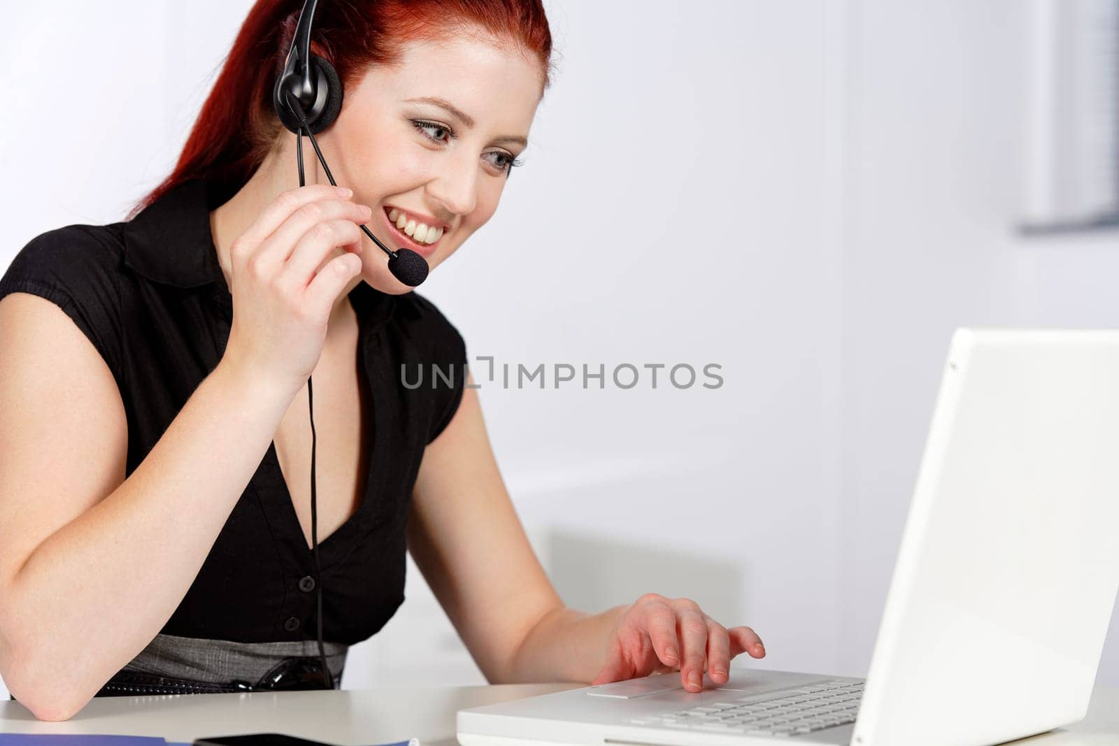 Professional woman talking on a headset in her office at work