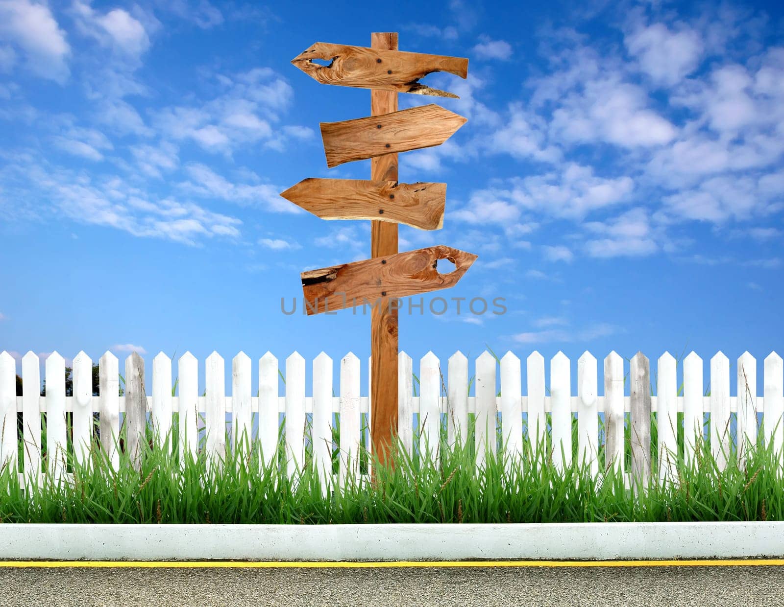 wooden signpost with white fence and blue sky