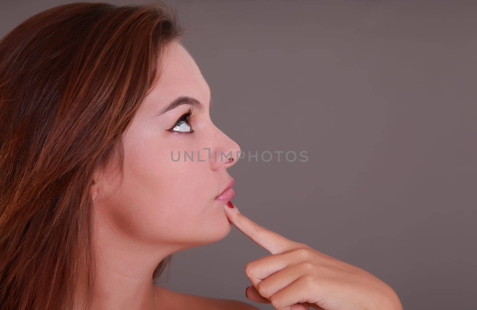 Nice girl looking on the right and finger on the chin