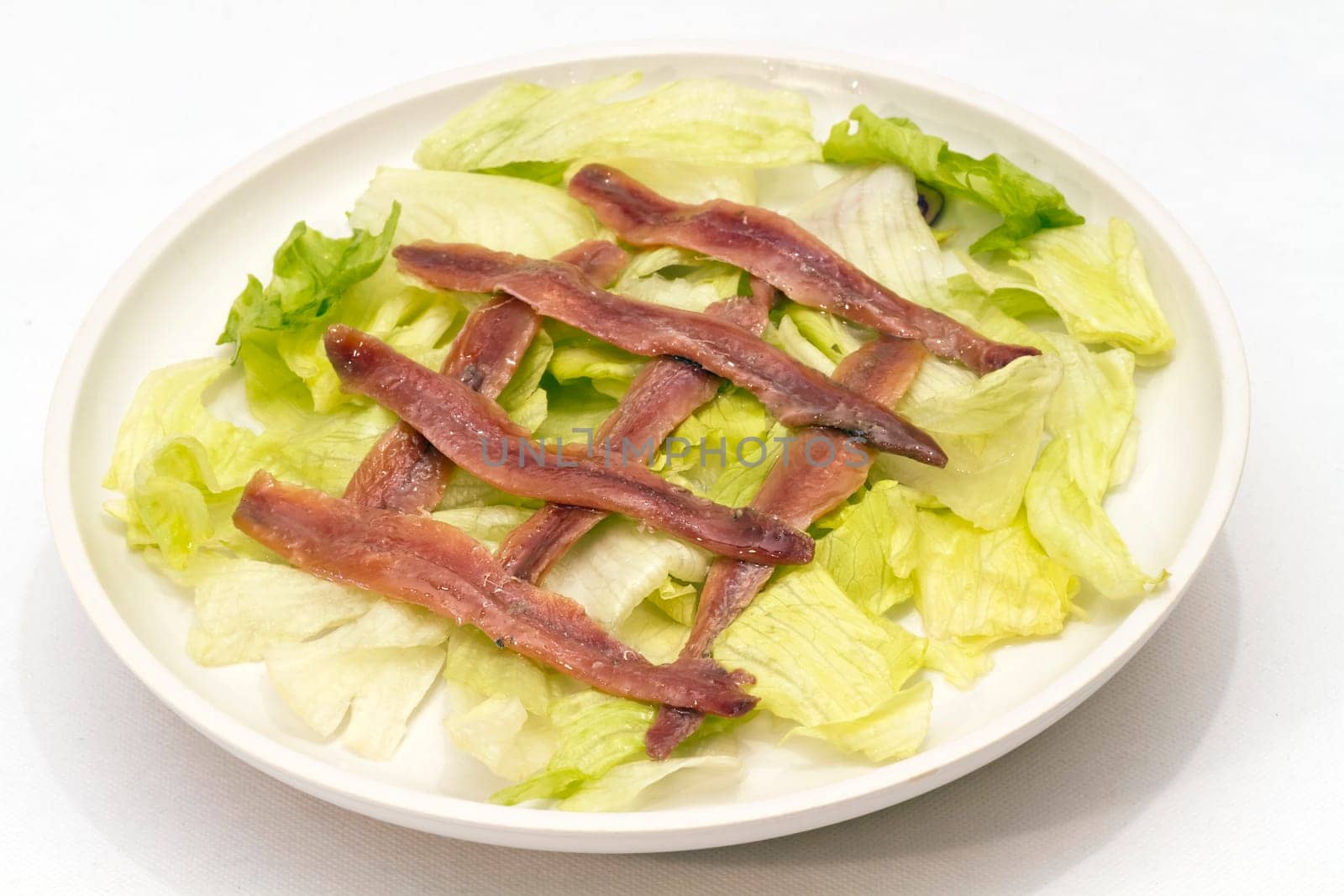 ration of anchovies in vinegar, garnished with tomato and mint
