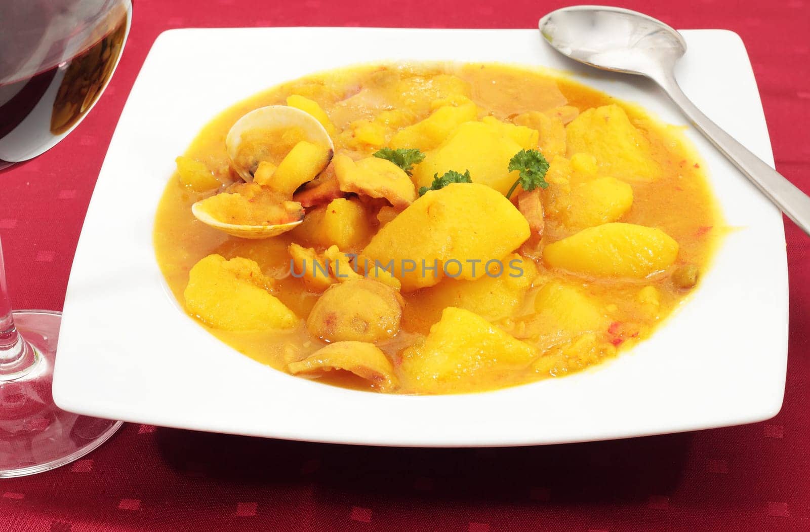 dish of boiled potatoes with clams squid and fish accompanied by wine