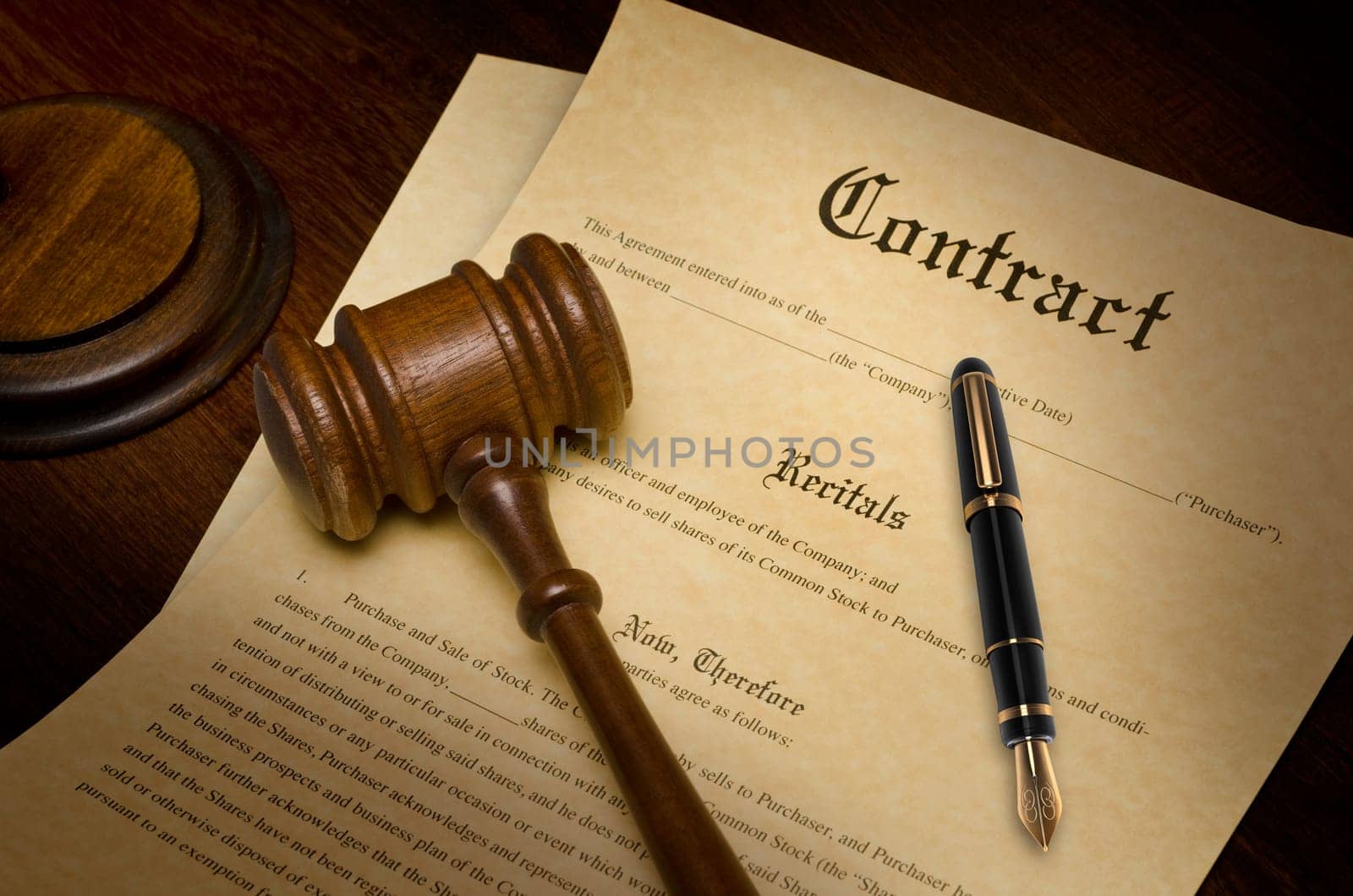 Contract on a wooden desk with a gavel and fountain pen