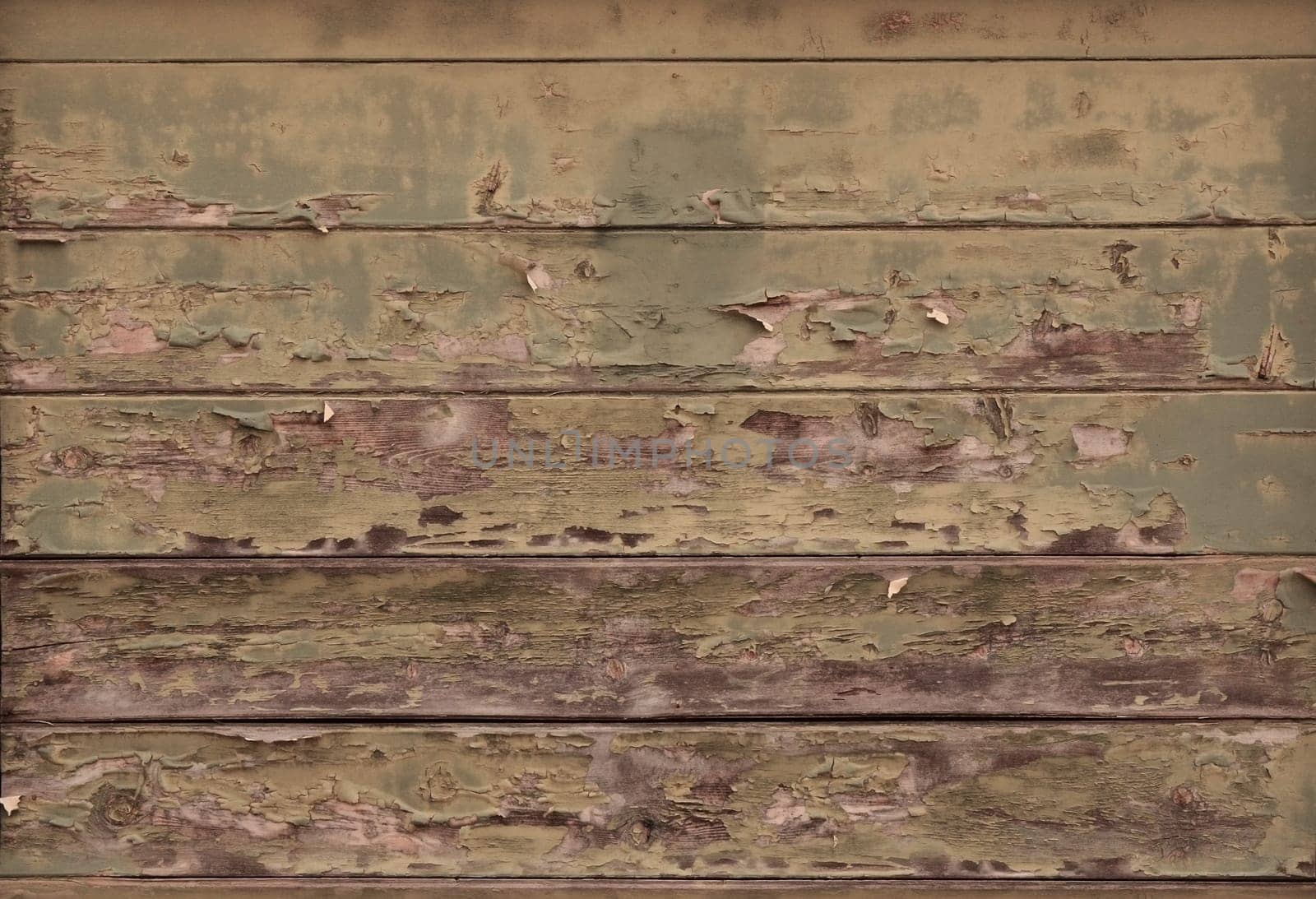 Distressed wood planks on an aged building showing blistered paint and wood grain