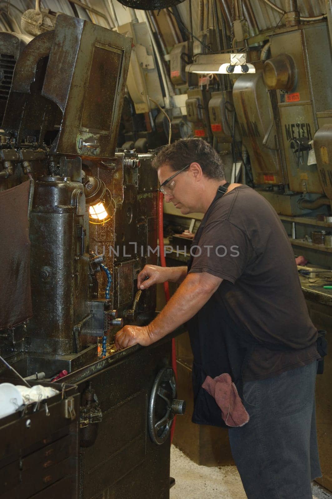 Metal worker in a factory operating a heavy machine