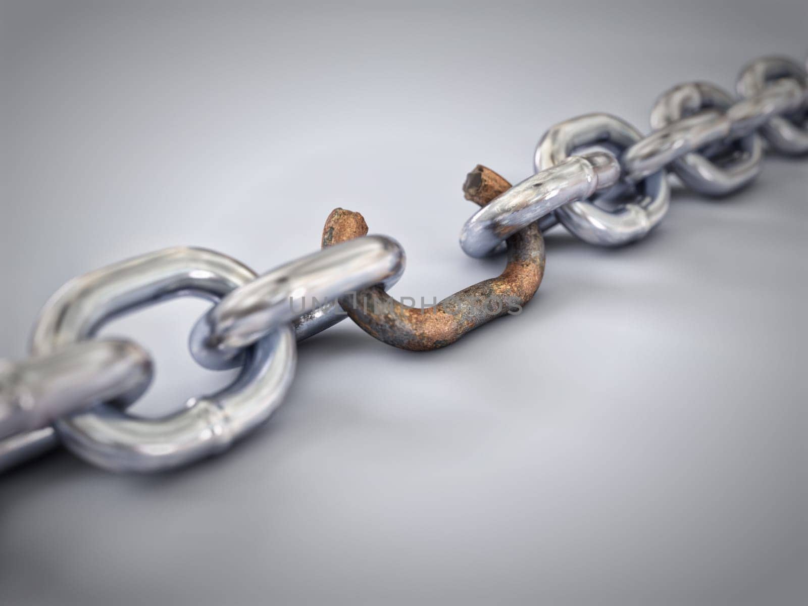 A chain with a broken rusted link showing weak link.