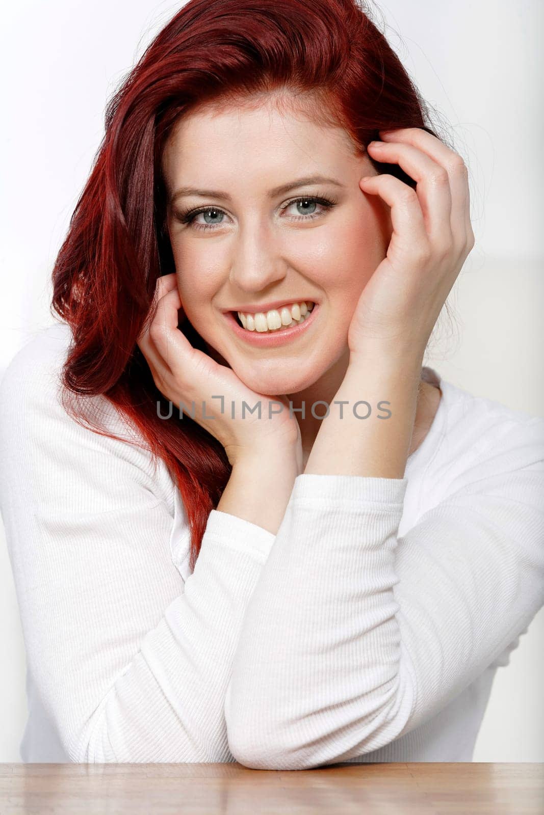 Beautiful young woman resting on a coffee table in front of sofa at home.