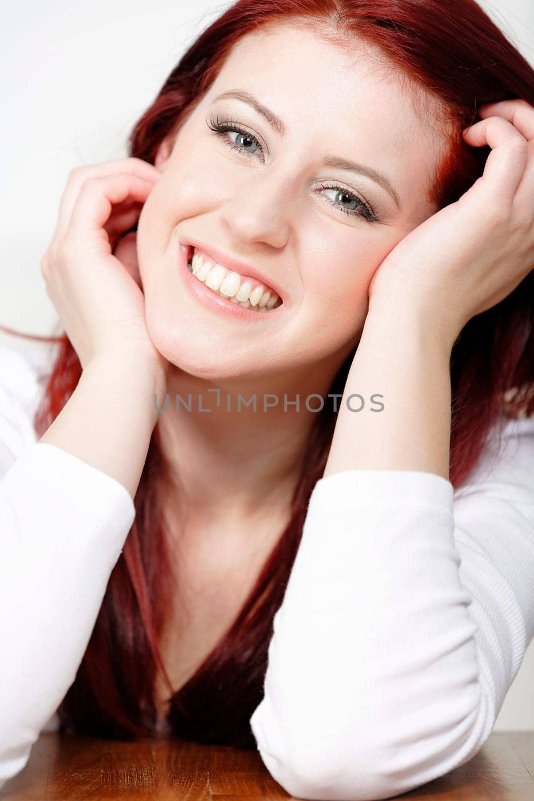 Beautiful young woman resting on a coffee table in front of sofa at home.