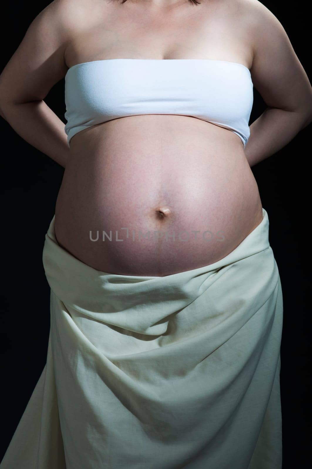 Cropped shot of baby belly in caucasian woman.