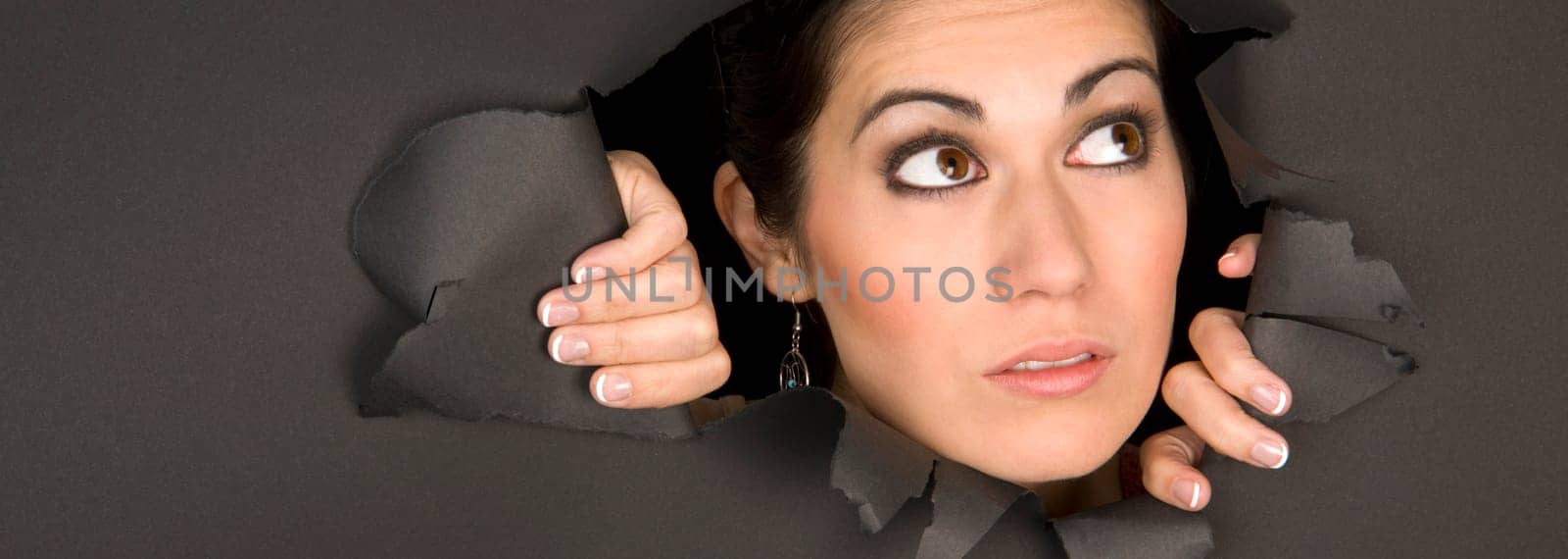 A beautiful and curious brunette peeks in through a hole