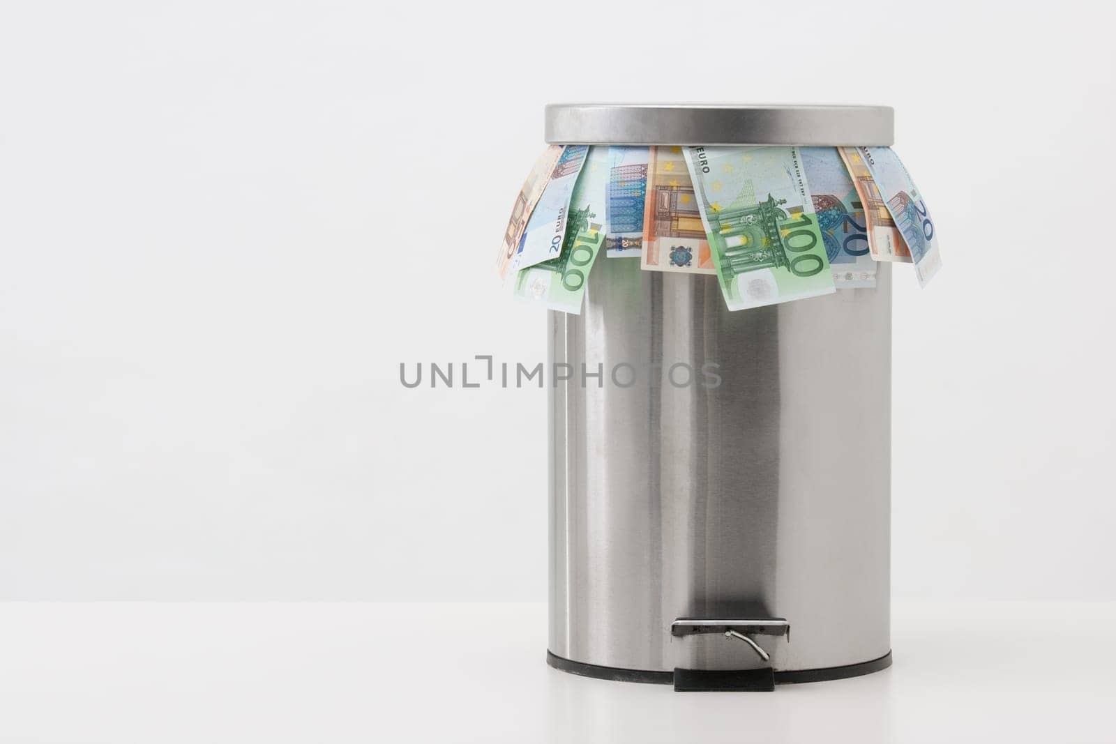 Money concept - throw money into waste bin. Unreasonable using of money.