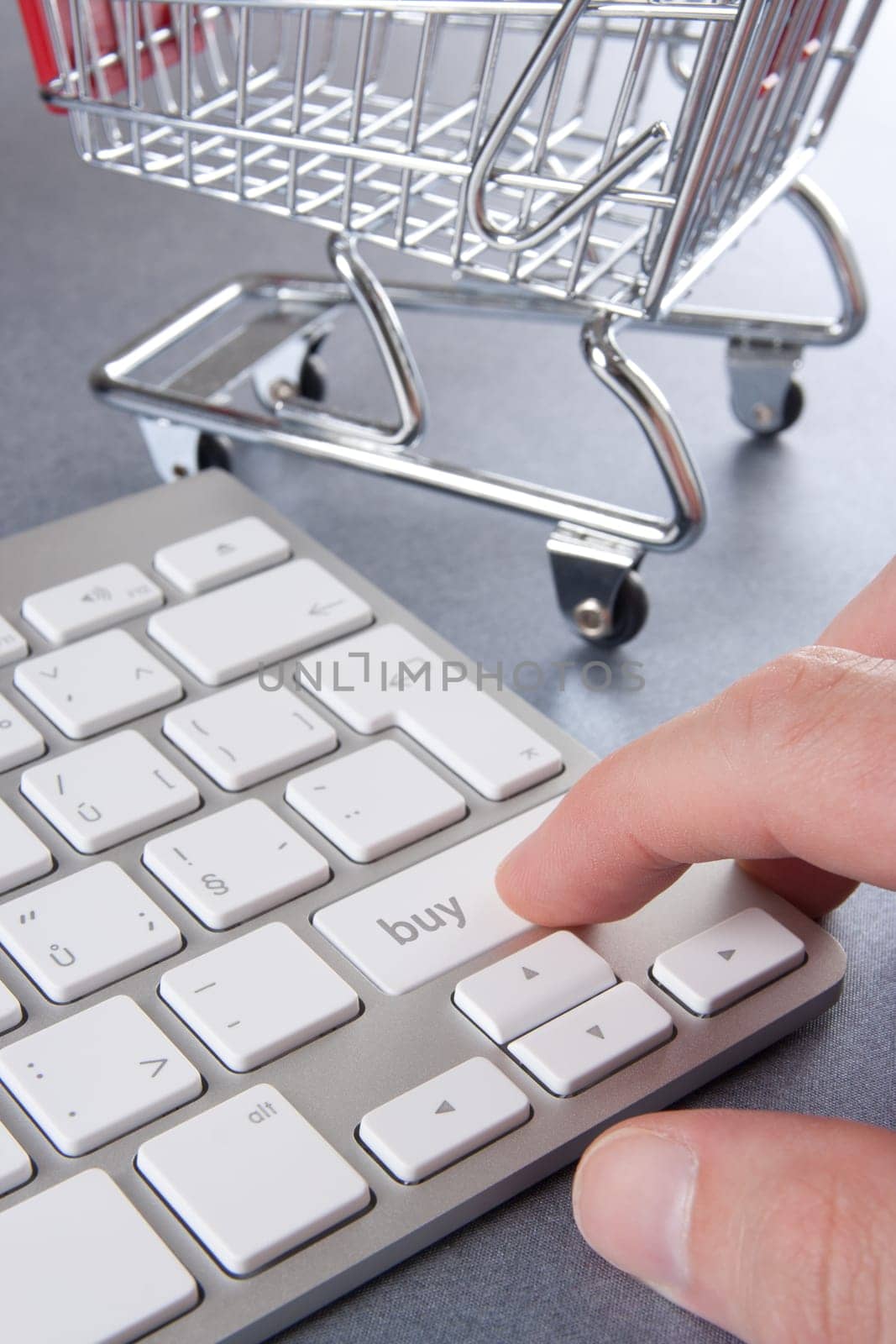 E-shop (e-commerce) concept - keyboard with buy text and shopping cart (shopping trolley) in background.