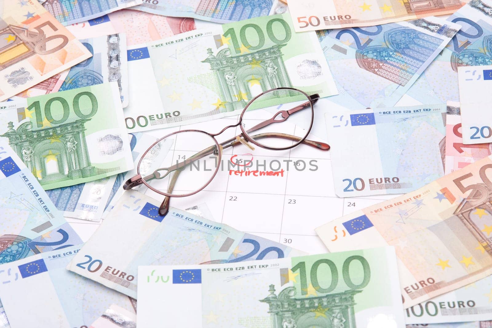 Look forward retirement payday - retirement written in calendar, money and glasses.