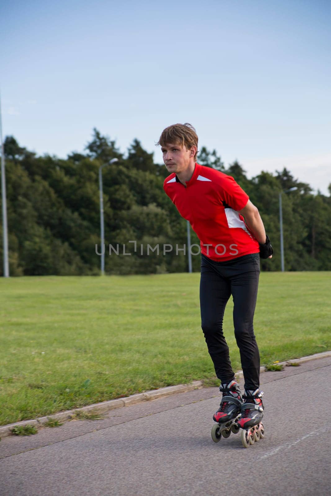 Young sportsman on new roller skates ride directly