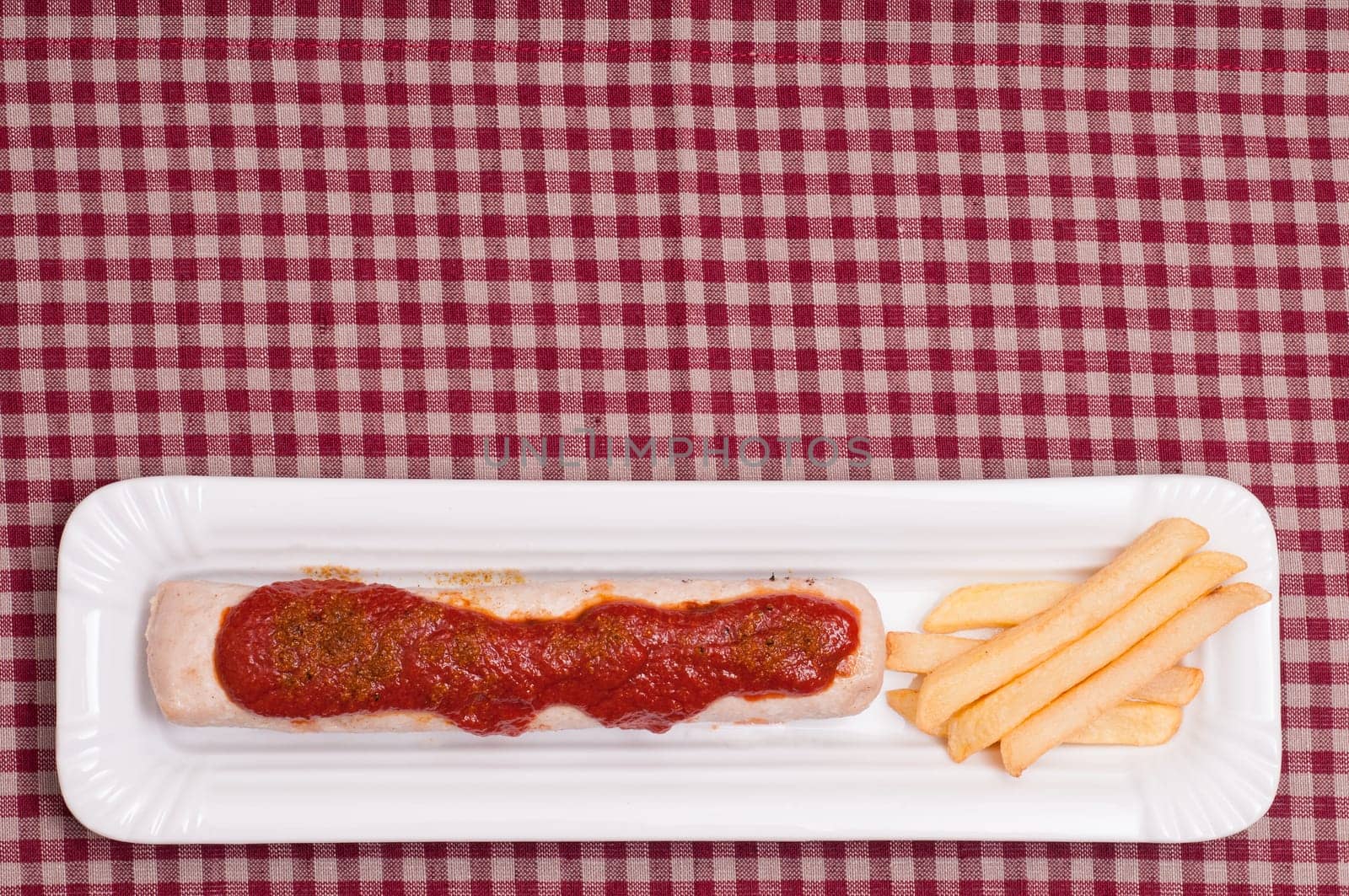 Currywurst with curry sauce and French fries and text space