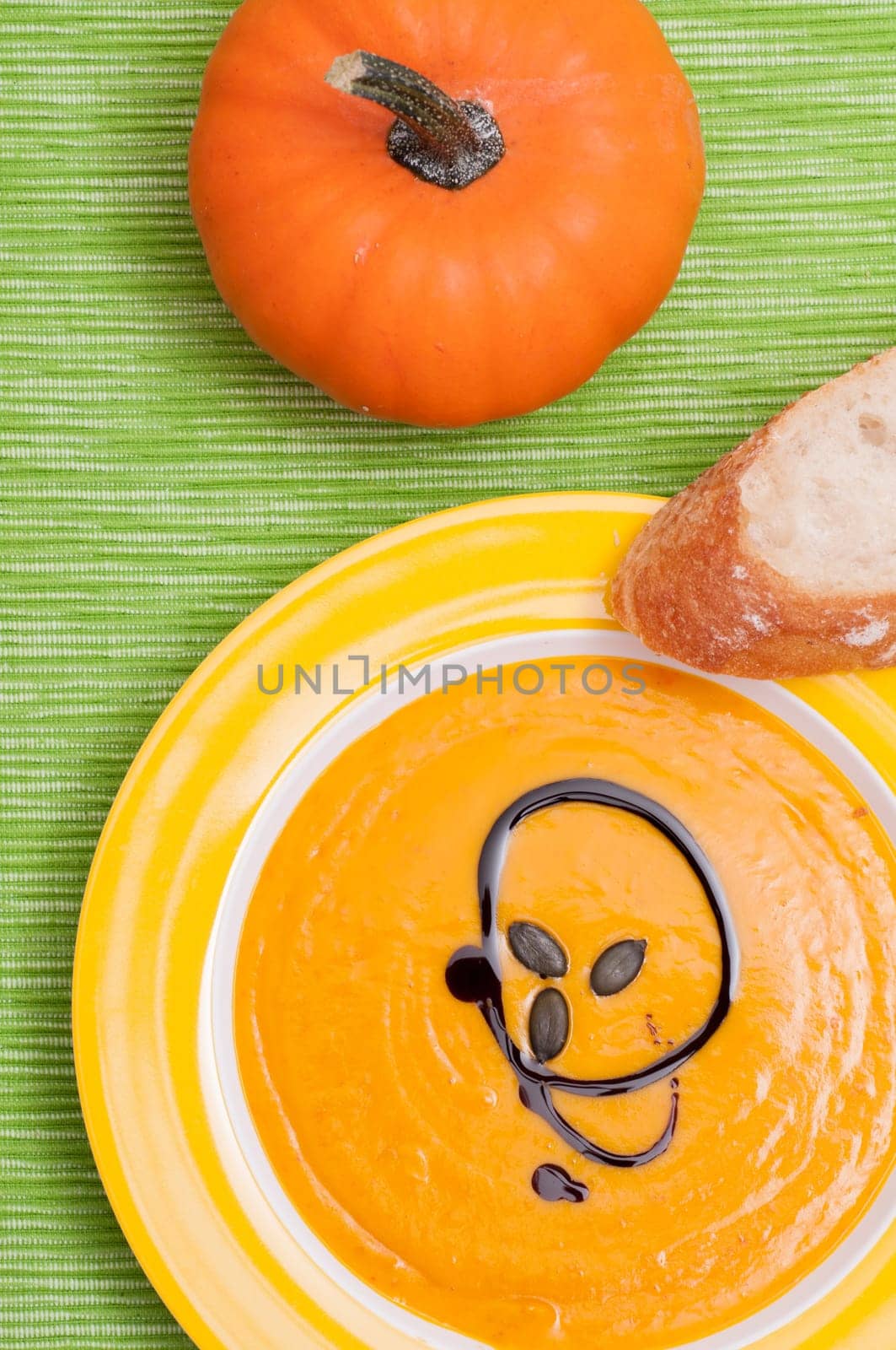 Pumpkin cream soup with bread and ornamental pumpkin