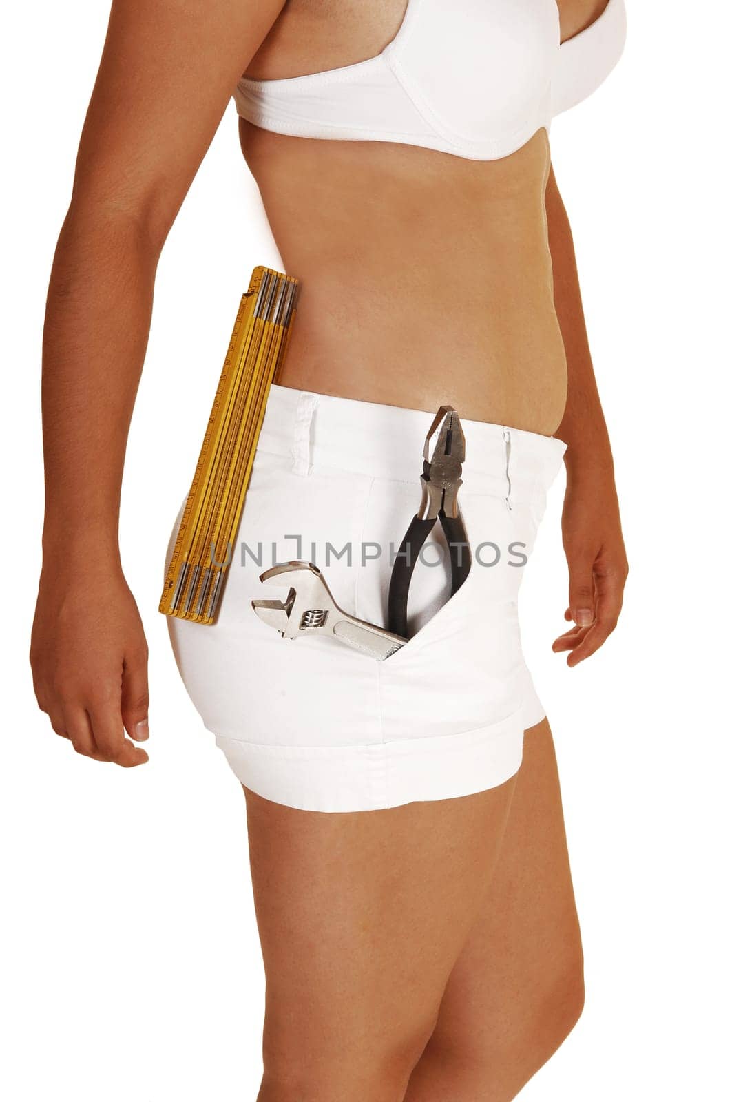 A young slim woman in white shorts and a white bra with some tools in her shorts, planning to do some repair in her home, for white background.