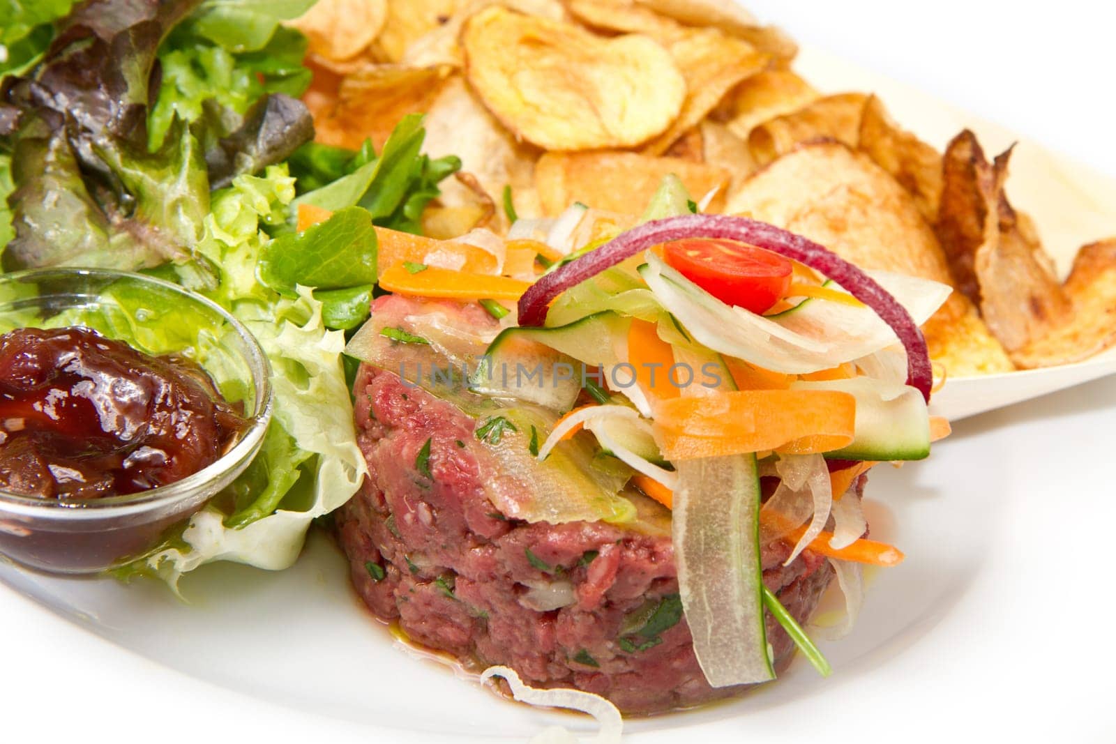 raw ground beef with chips and salad
