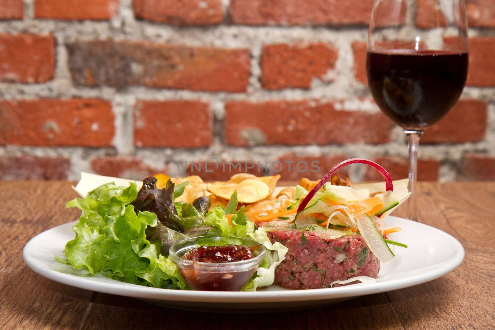 raw ground beef with chips and salad