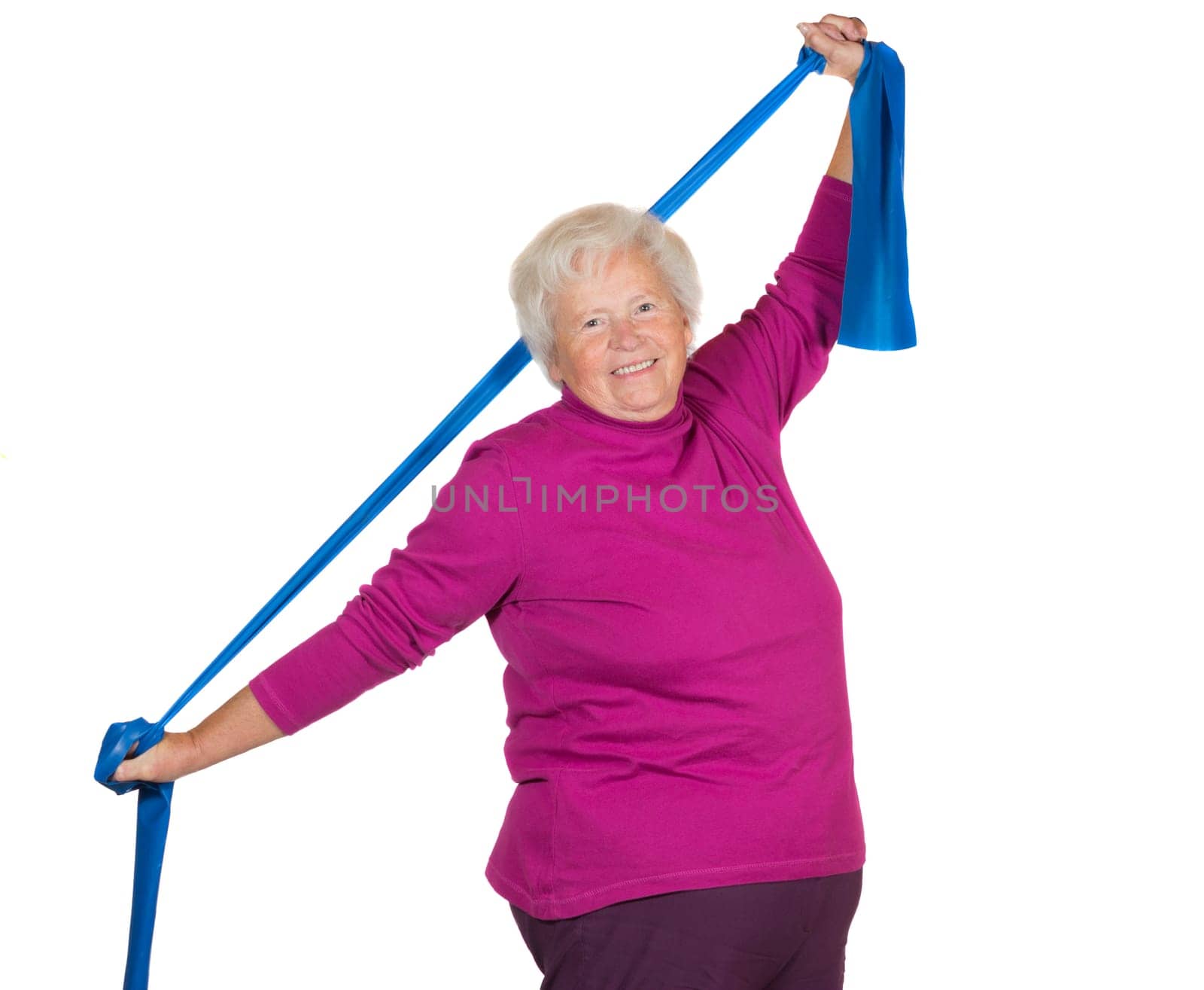 Happy overweight senior lady exercising stretching her arms above her head using a strap to improve her flexibility and strengthen her neck and shoulder muscles