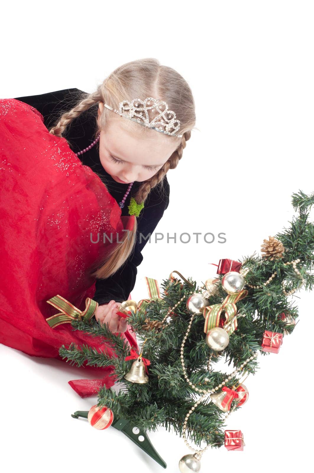 Cute girl with small christmas tree on white