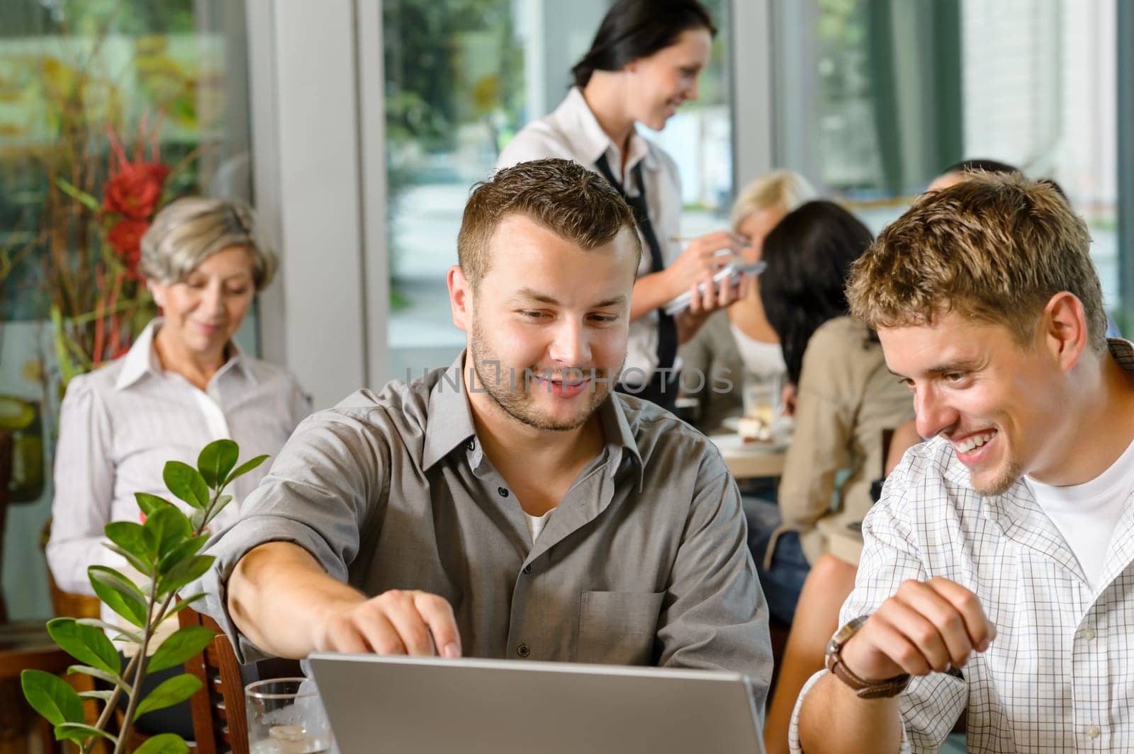 Men business partners working on laptop cafe restaurant