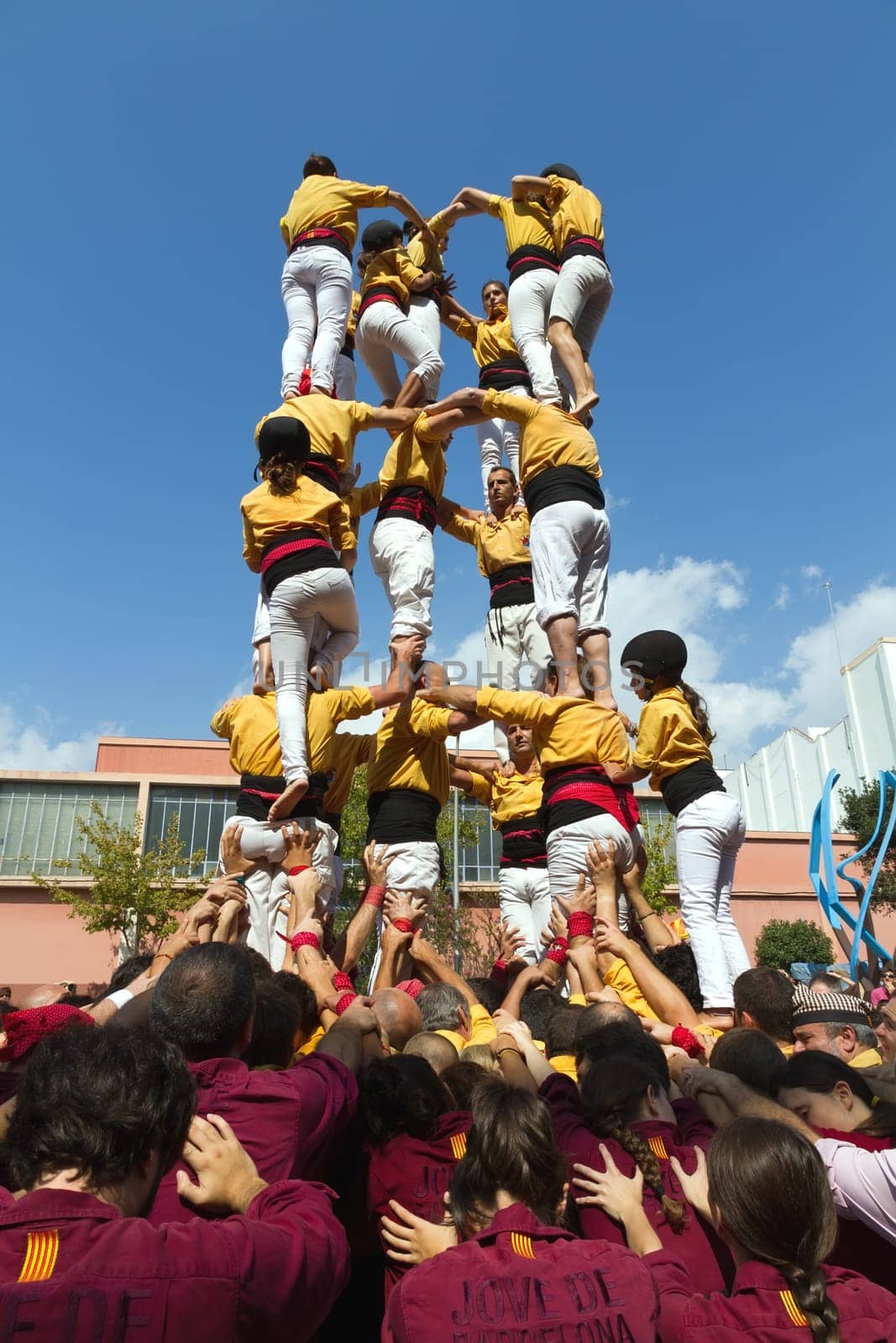 BARCELONA - SEPTEMBER 11: Some unidentified people called Castellers do a Castell or Human Tower, typical tradition in Catalonia, on September 11, 2012 in Barcelona, Spain.