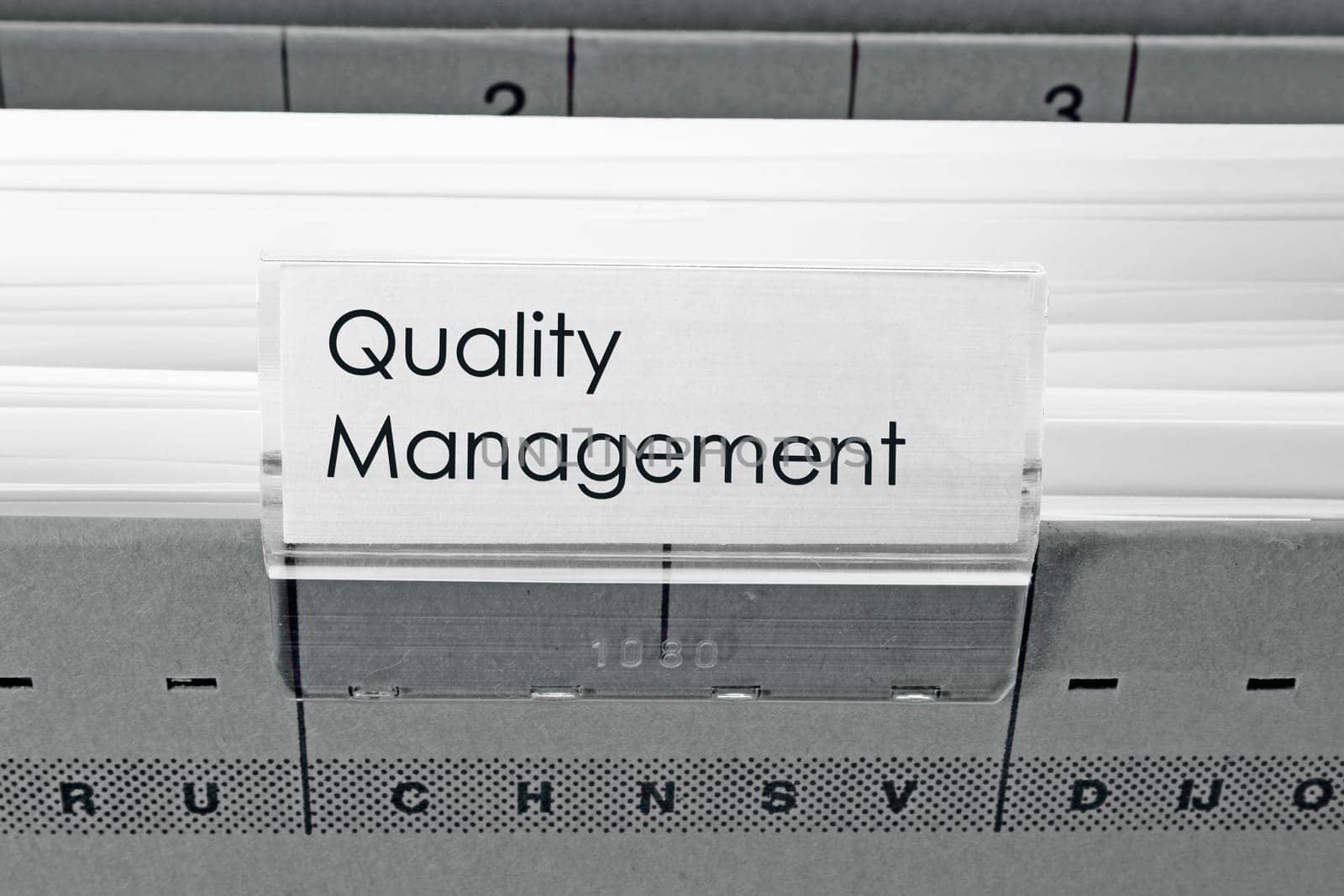 grey hanging file folder labeled with Quality Management