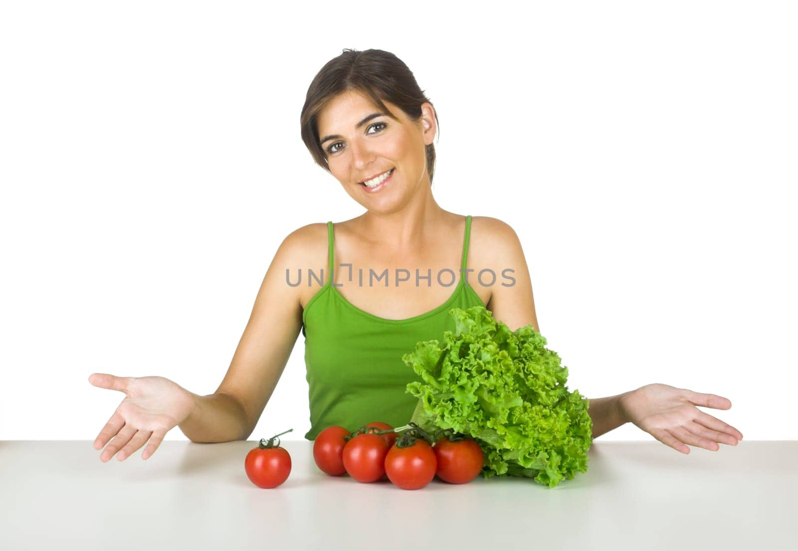 Beautiful young woman in the kitchen with healthy vegetables in front of her
