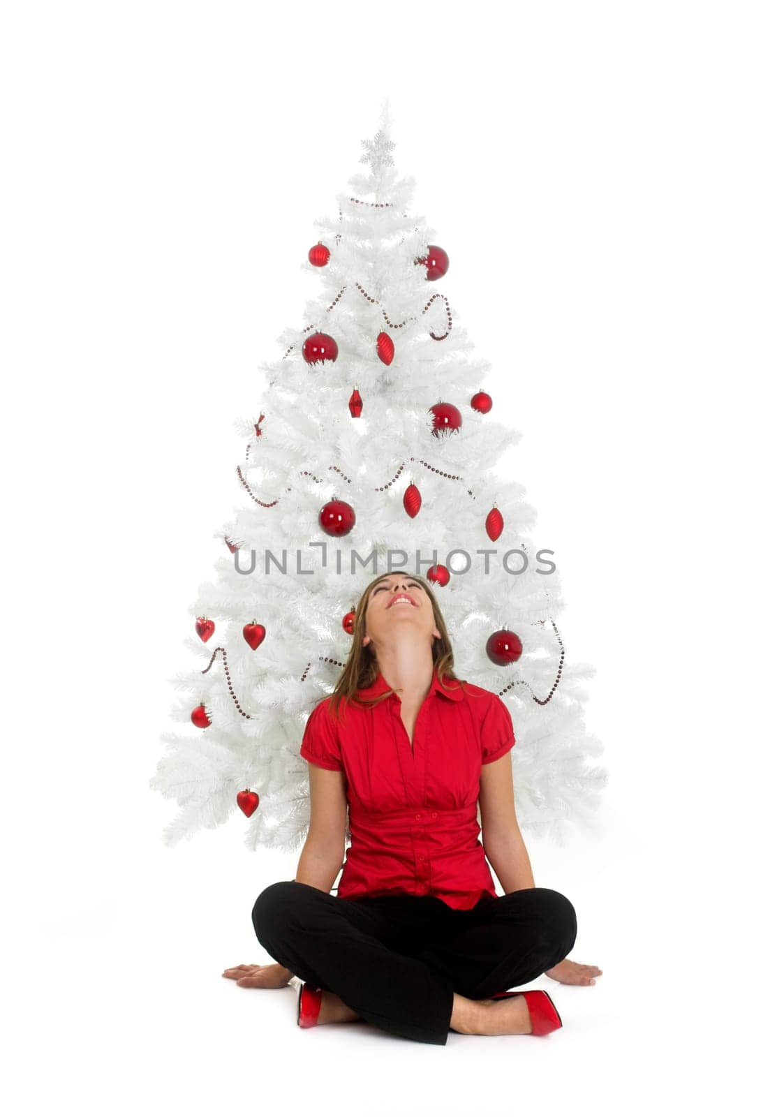 Beautiful attractive woman posing near a white Christmas tree