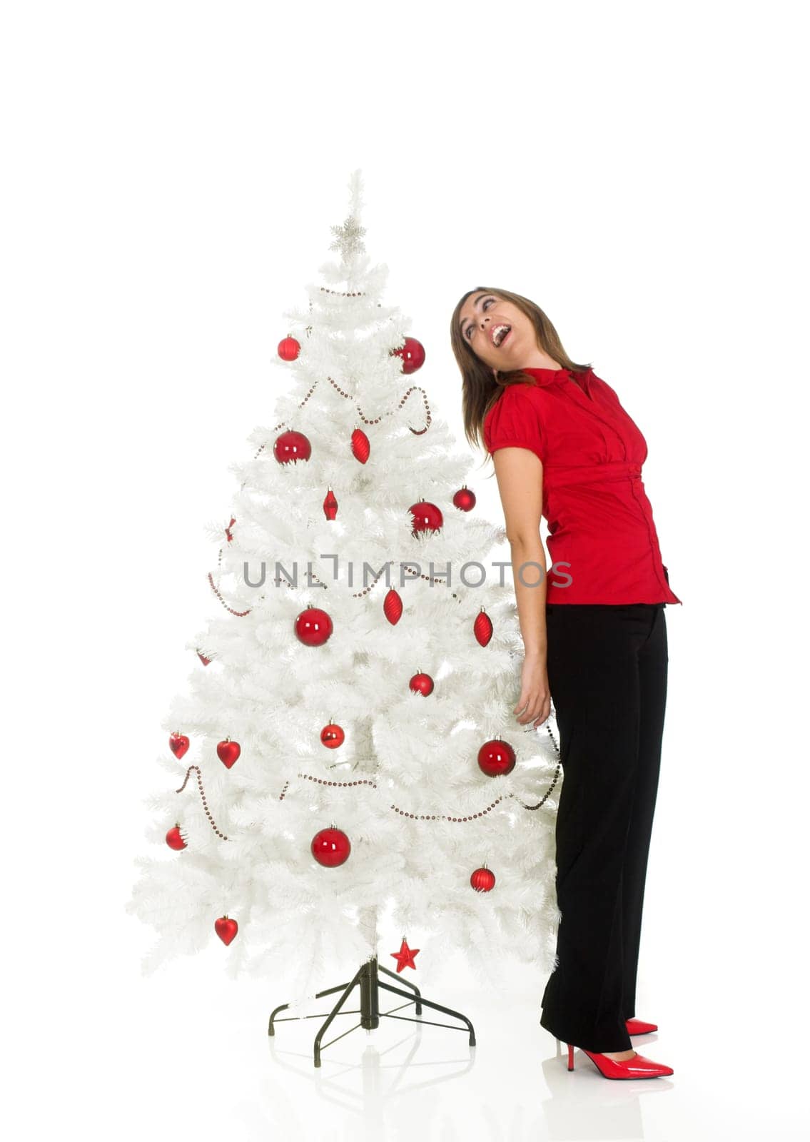 Beautiful attractive woman posing near a white Christmas tree