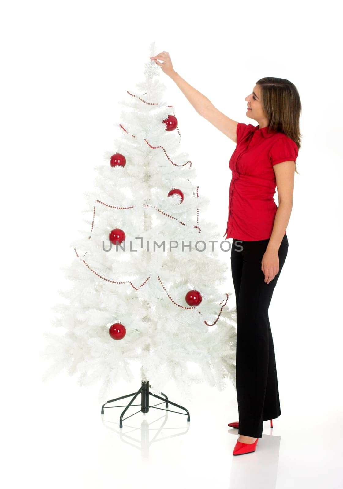 Beautiful attractive woman posing near a white Cristmas tree