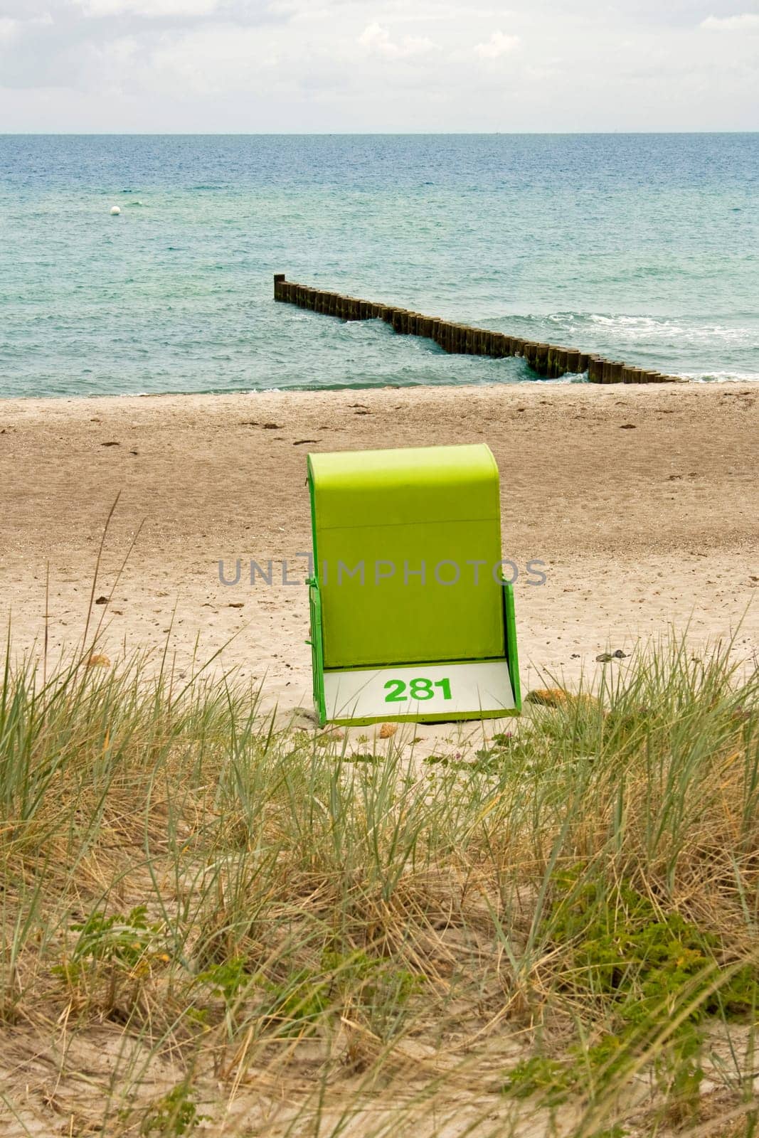 green beach chair standing alone at the sandy beach