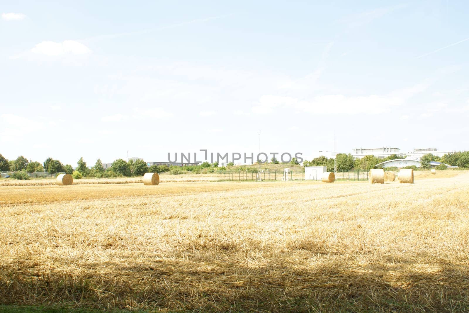 High key pick-up of straw bales in a mowed field.