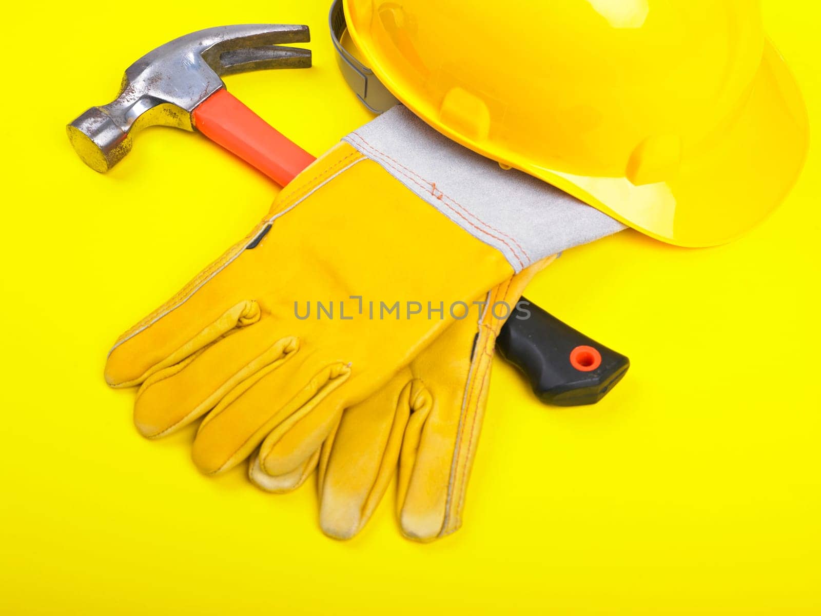 Worker equipment - HardHat Hammer And Leather Gloves on yellow