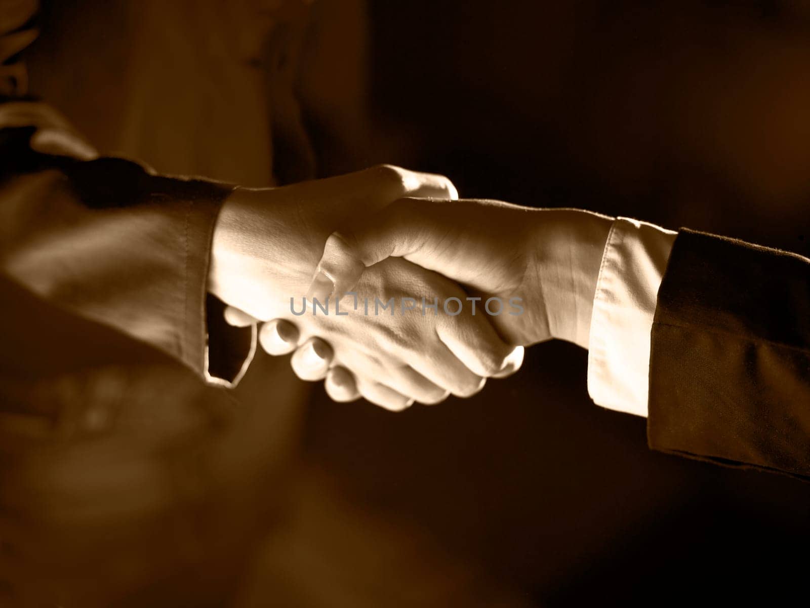 Handshake Handshaking dark and light, sepia tone