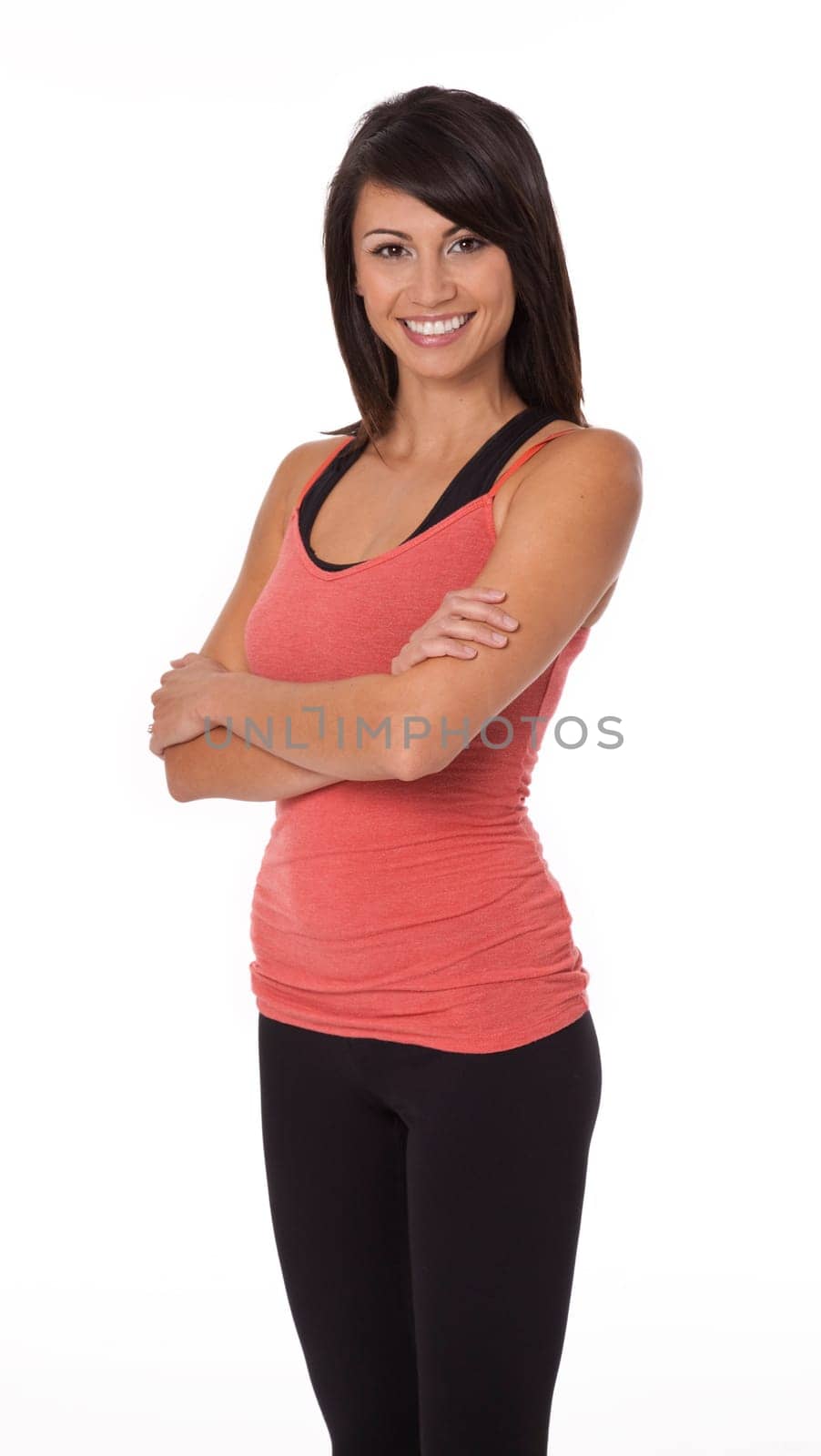 Woman wearing sportswear standing with arms crossed on white background.